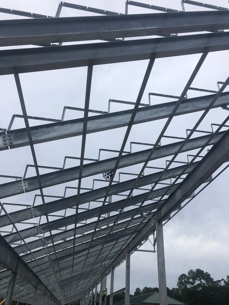 Steel framework of a building under construction against a cloudy sky.