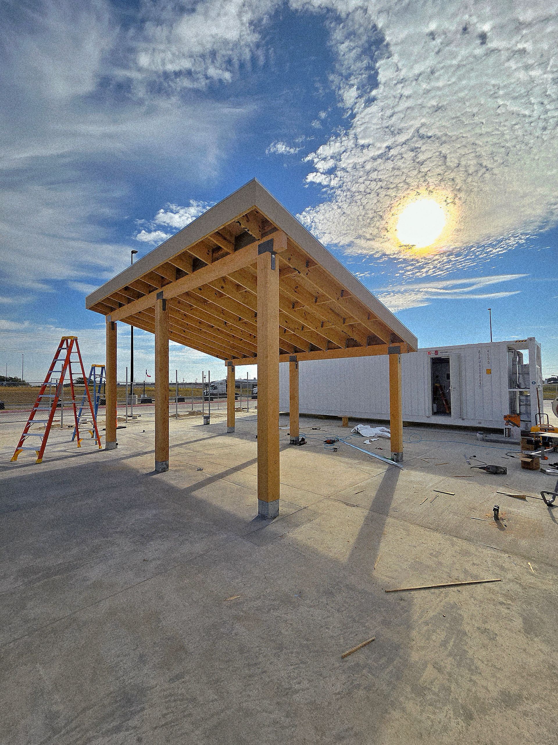 Wooden carport under construction on a sunny day.