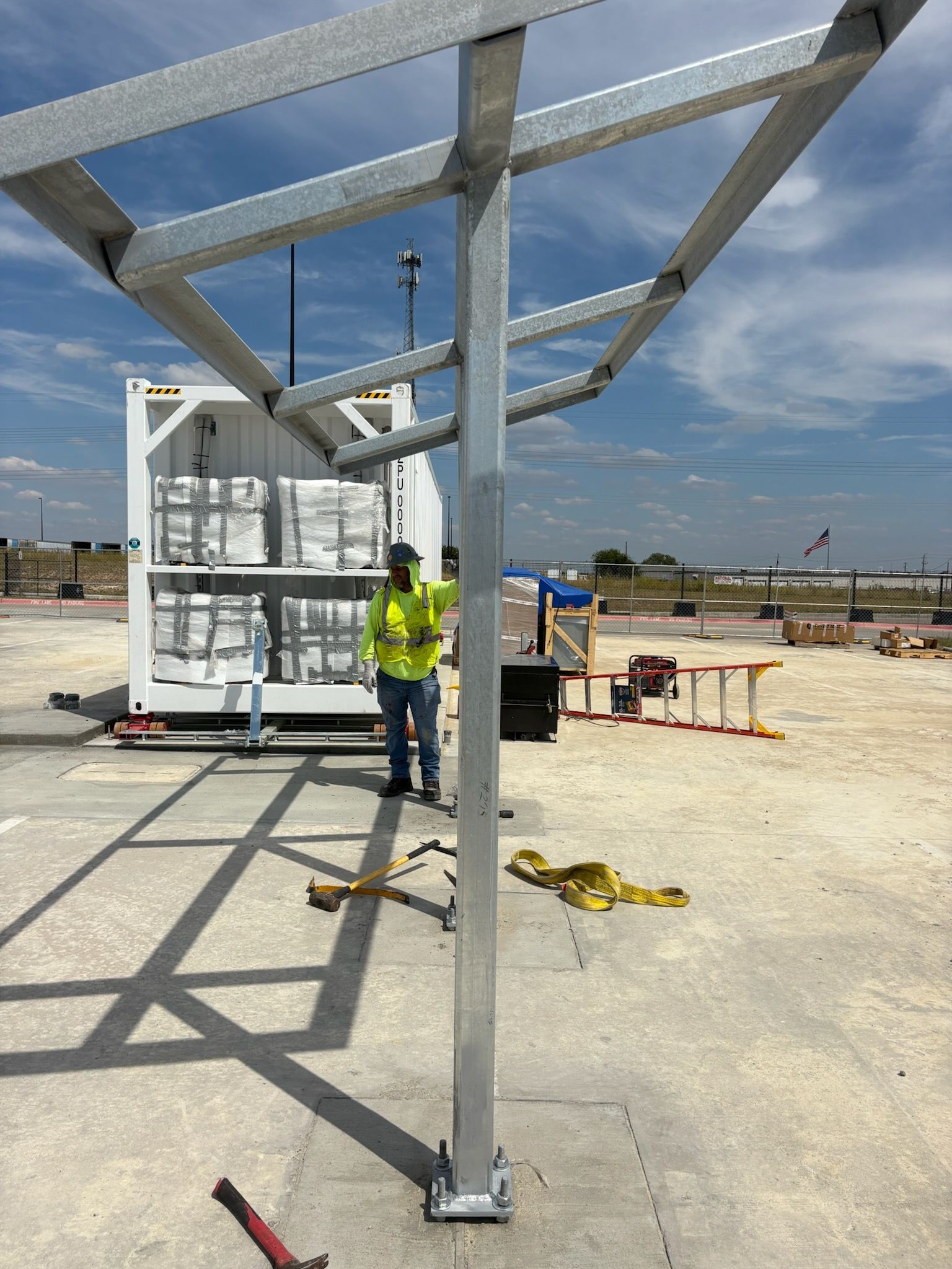 Exterior of a building with a metal awning and a walkway. Cloudy sky above.