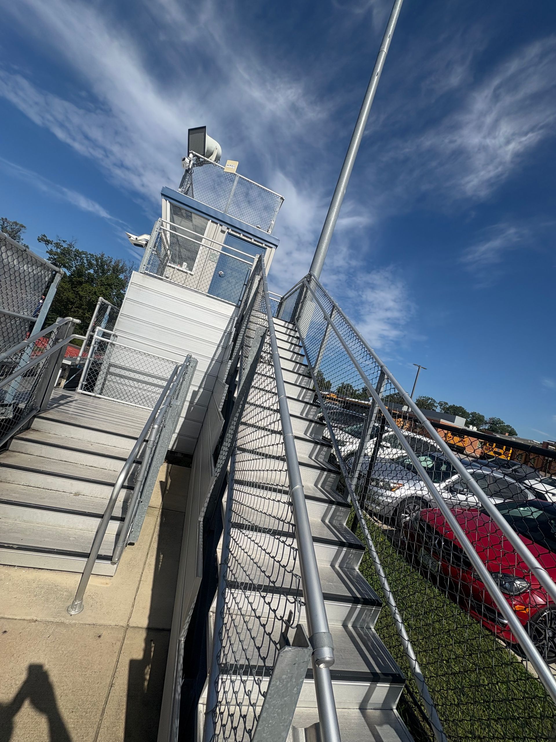 Metal staircase leading up to a watchtower with a sunny blue sky.