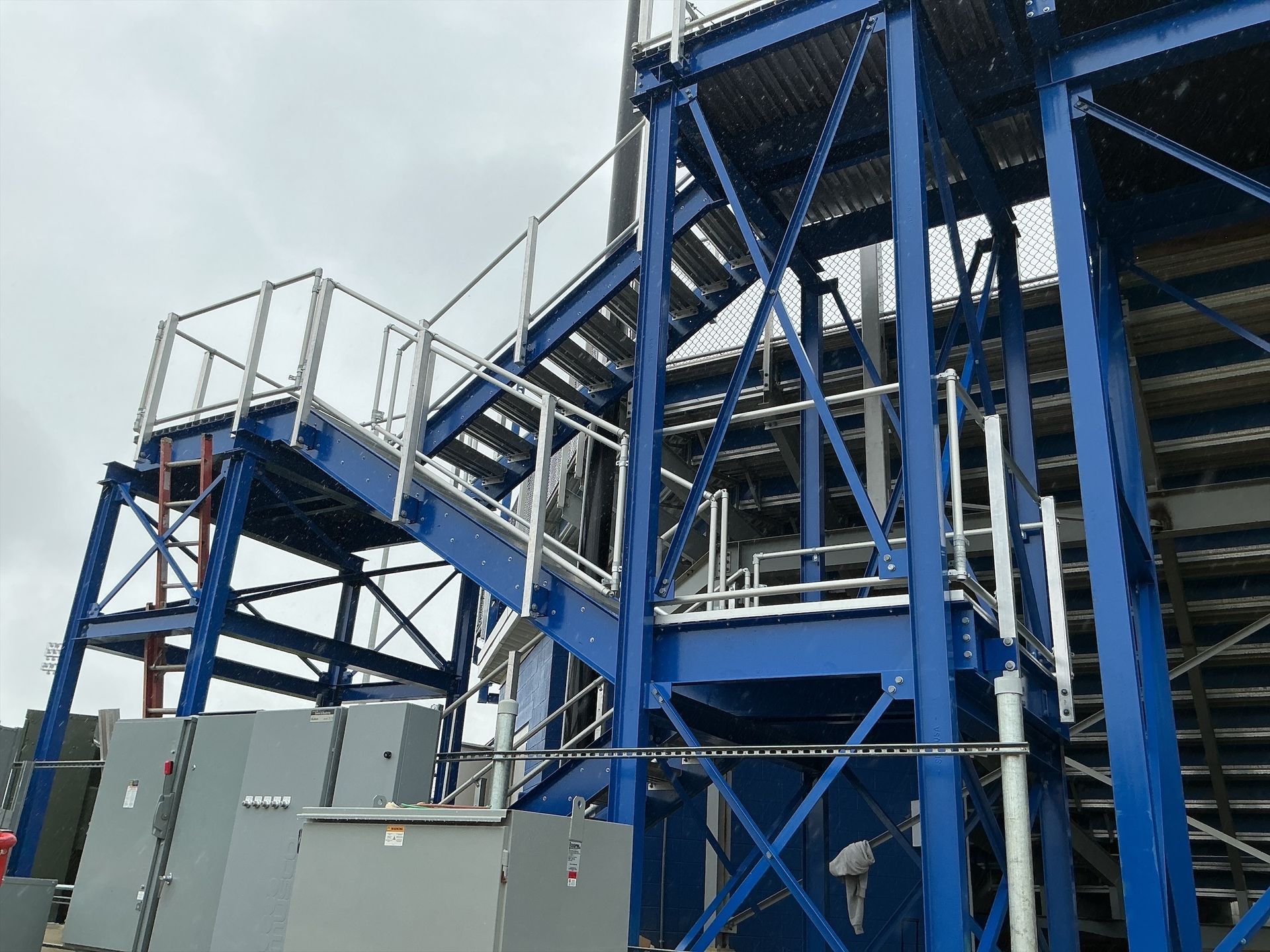 Blue metal staircase and platform structure outdoors.