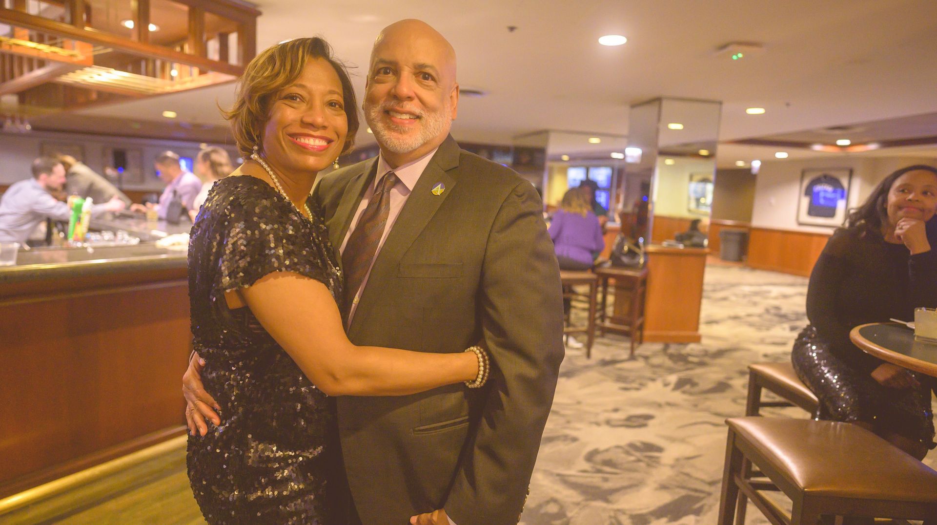 A man and a woman are posing for a picture in a restaurant.