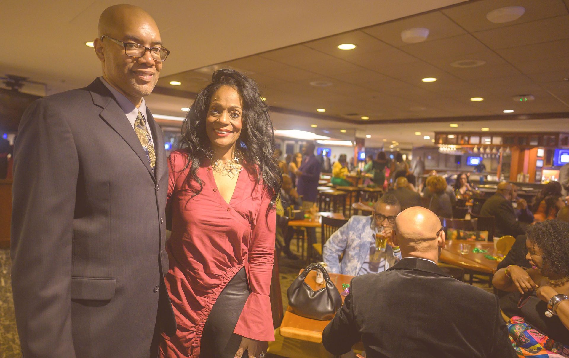 A man and a woman are standing next to each other in a restaurant.