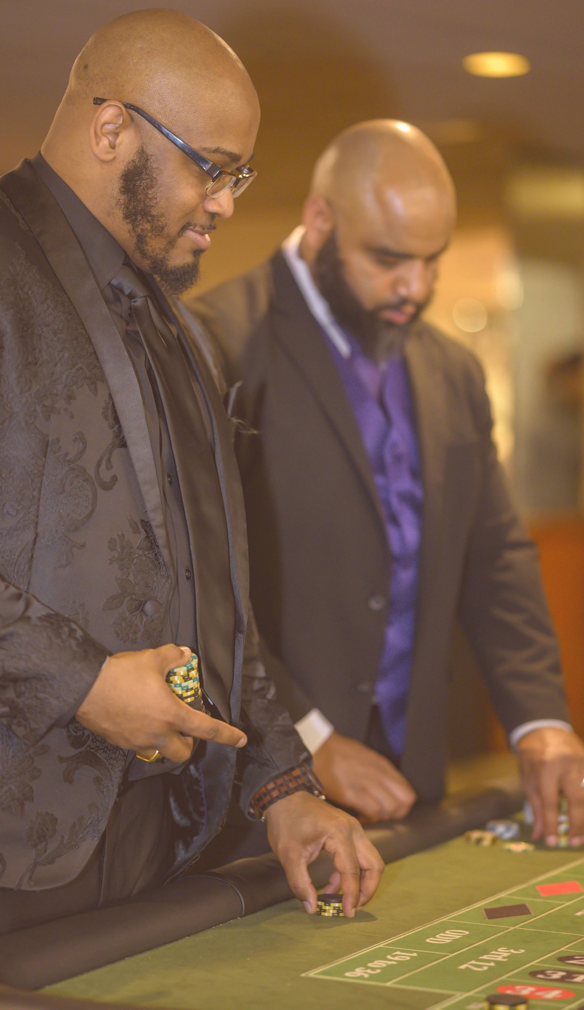 Two men are playing roulette at a casino table.