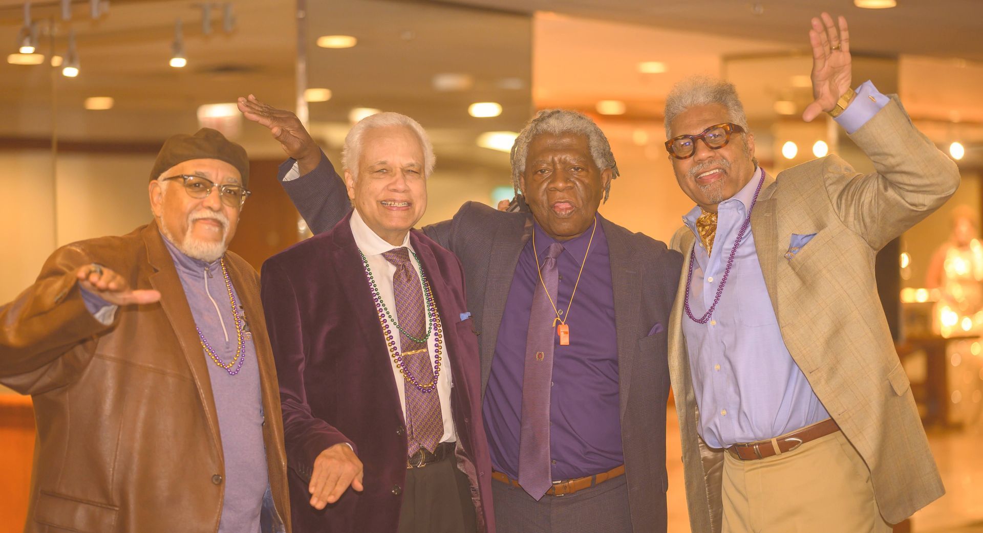 A group of four men are posing for a picture together.