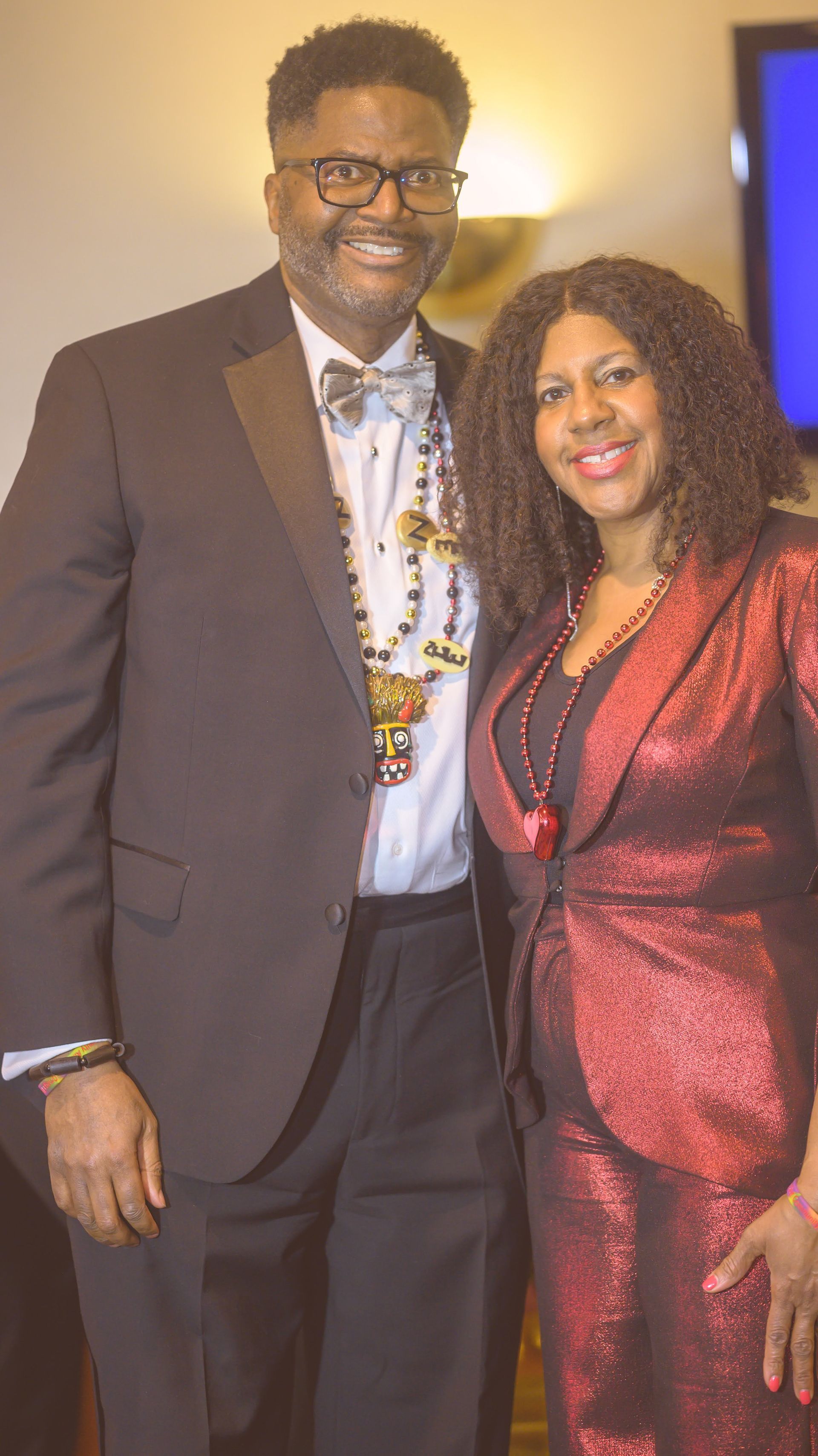 A man in a tuxedo and a woman in a red dress are posing for a picture.