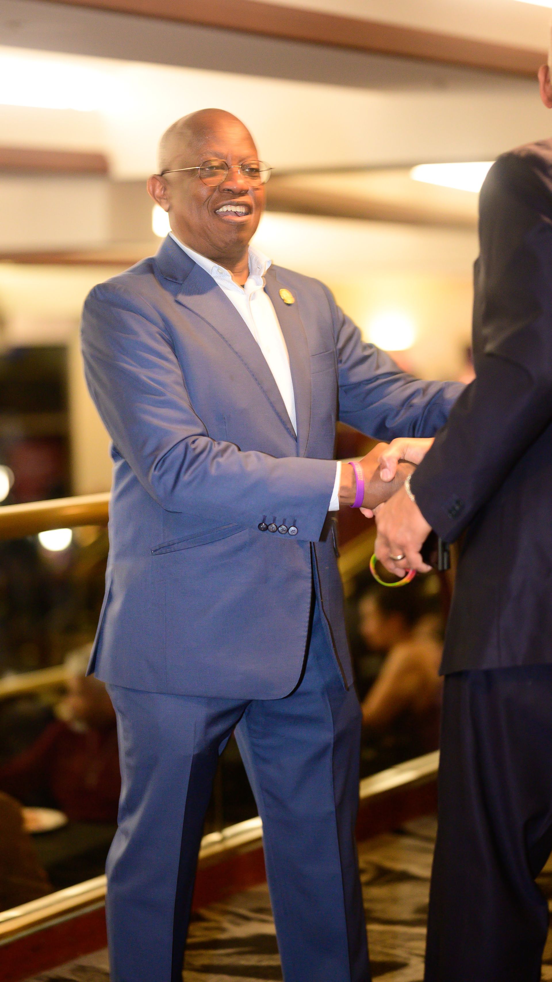 A man in a suit is shaking hands with another man.