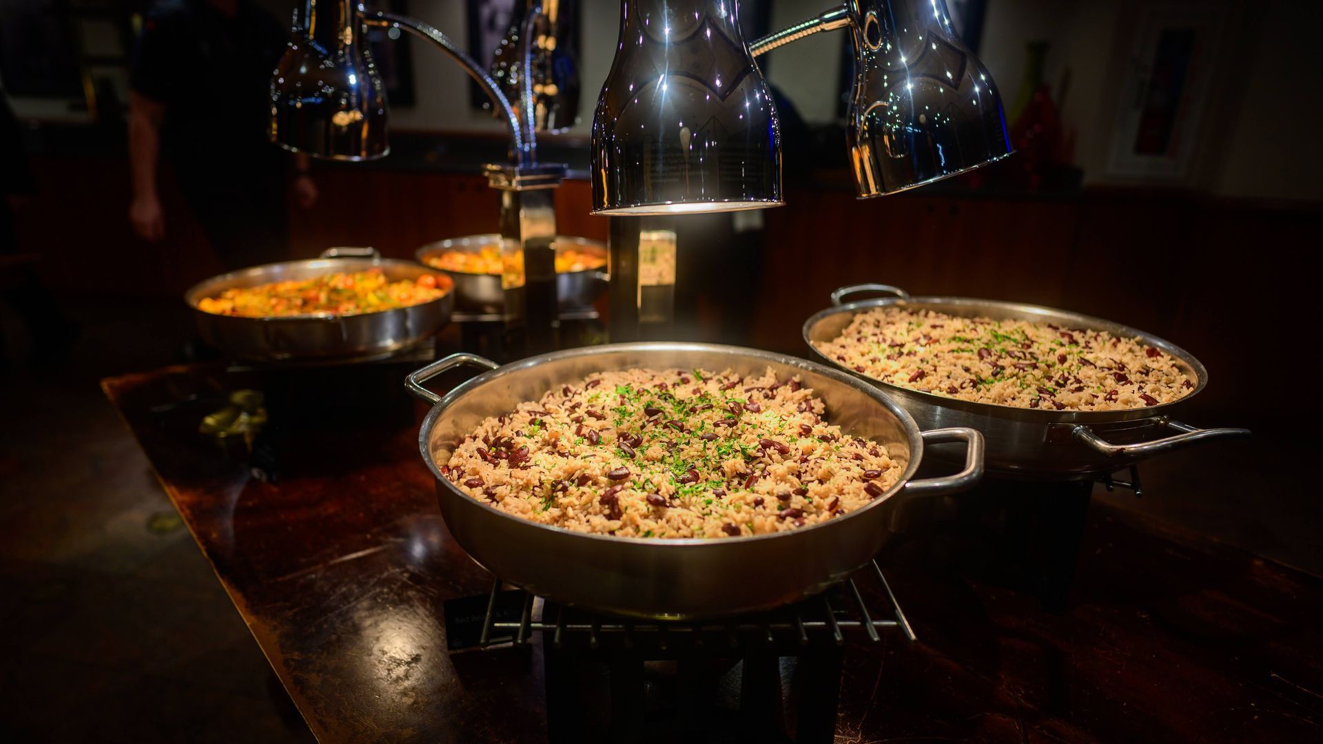 Three pans of food are sitting on top of a wooden table.