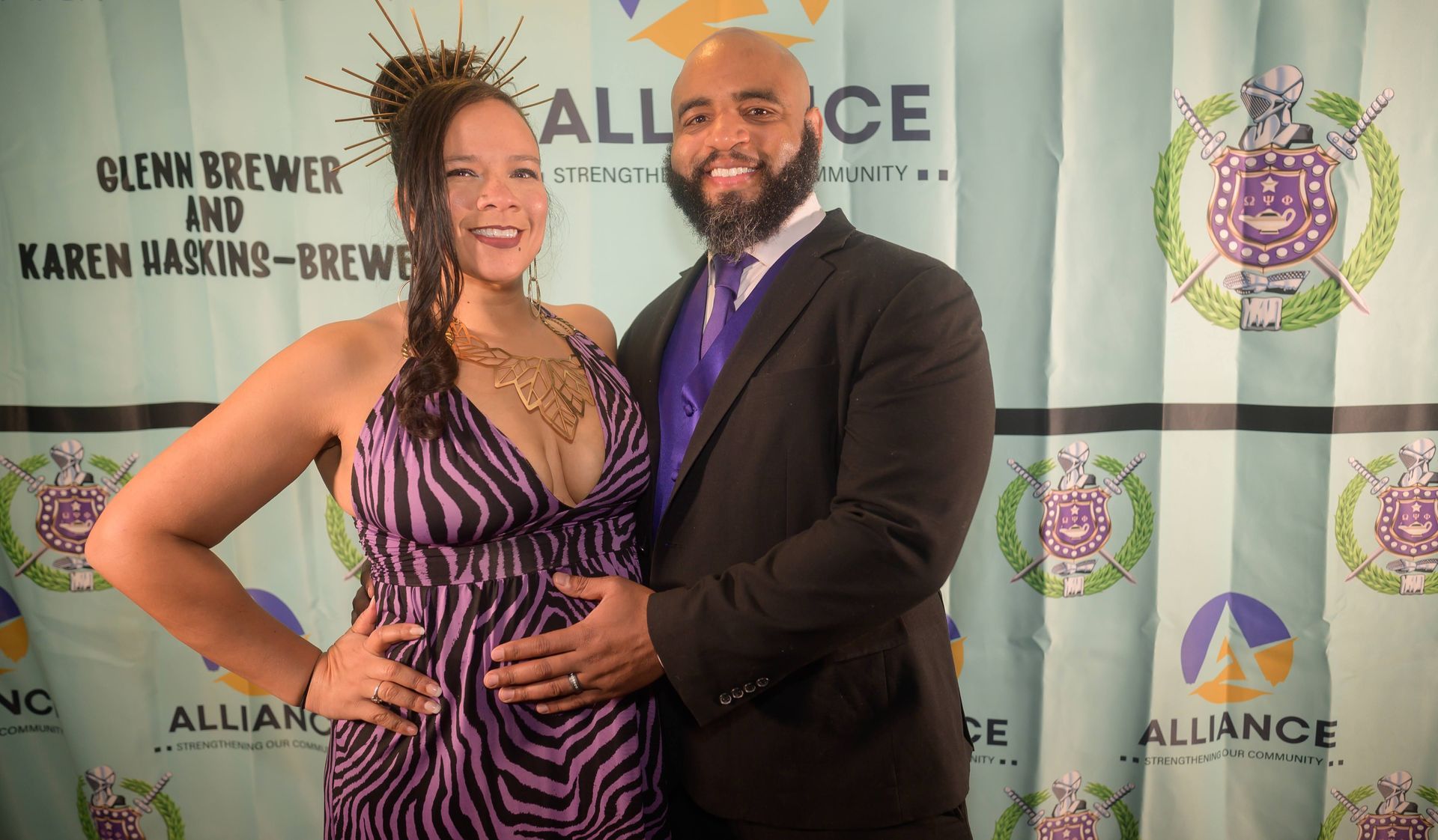 A man and a woman are posing for a picture on a red carpet.