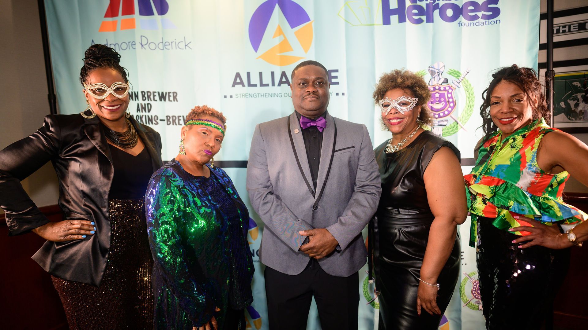 A group of people are posing for a picture in front of a sign that says alliance heroes.