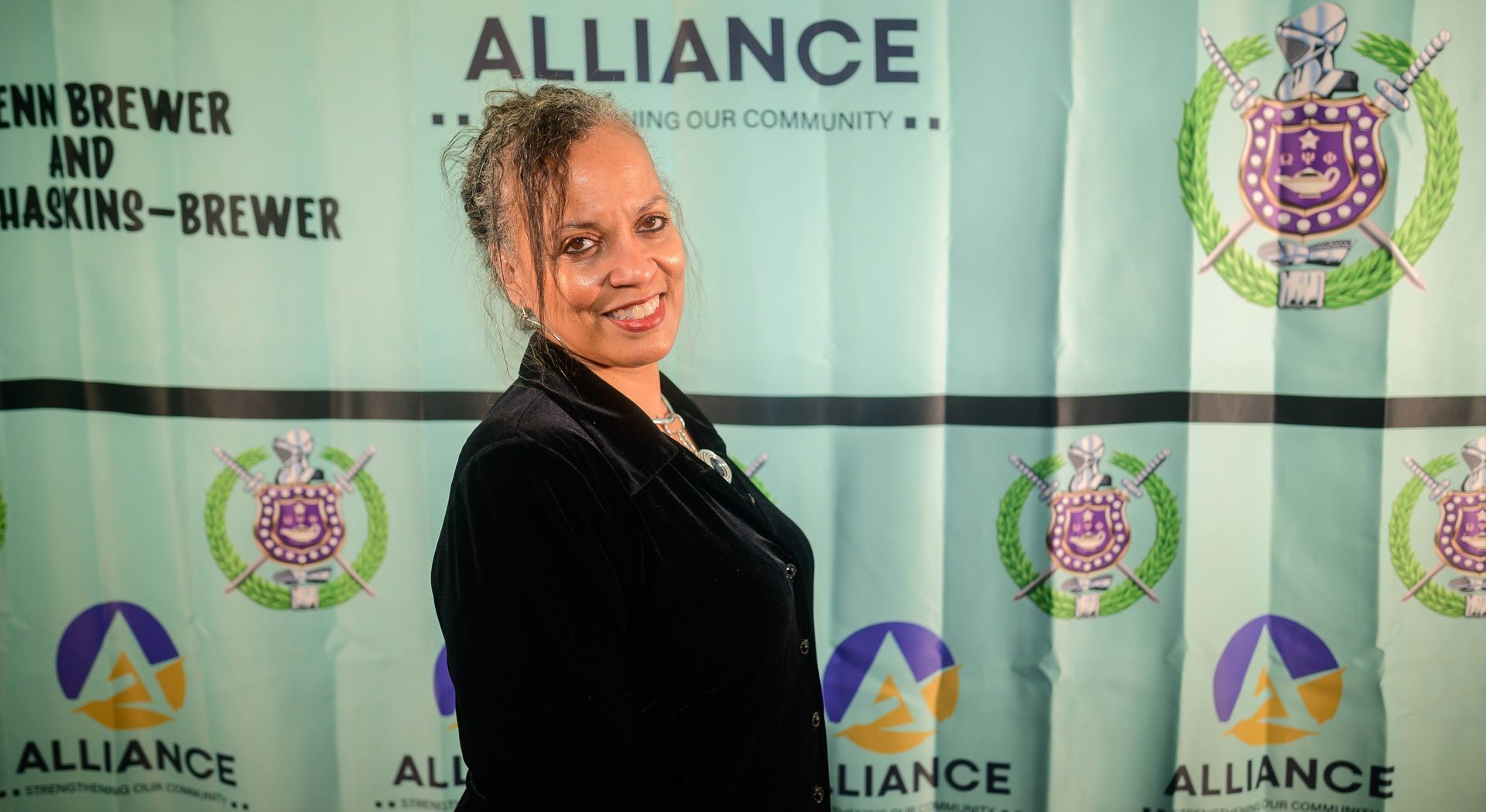 A woman is standing in front of a alliance banner.