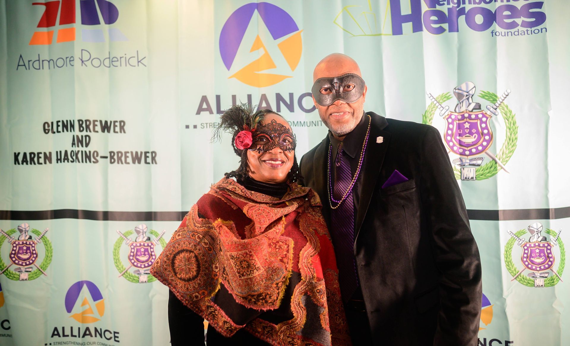 A man and a woman are posing for a picture in front of a banner that says alliance heroes.
