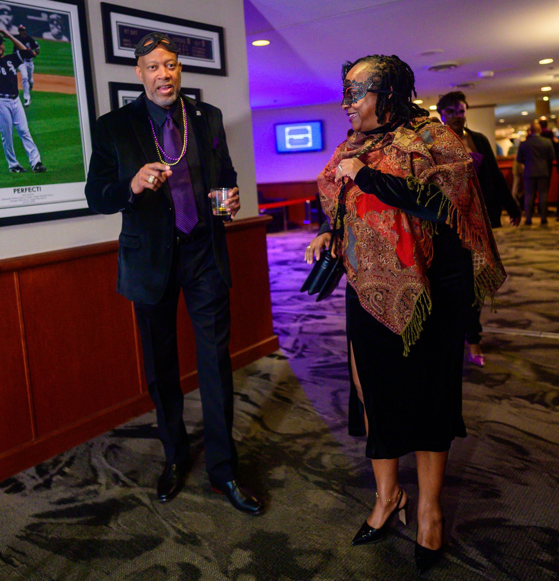 A man in a suit and tie stands next to a woman in a mask