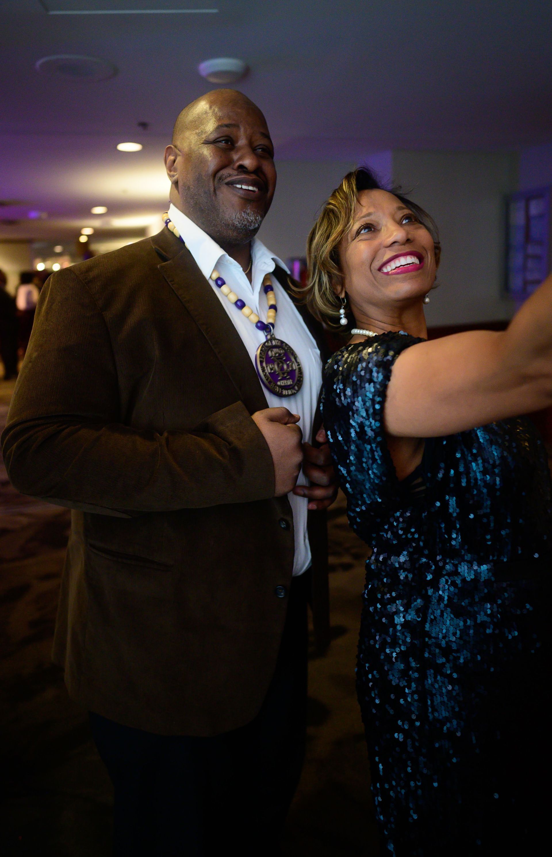 A man and a woman are taking a selfie together at a party.