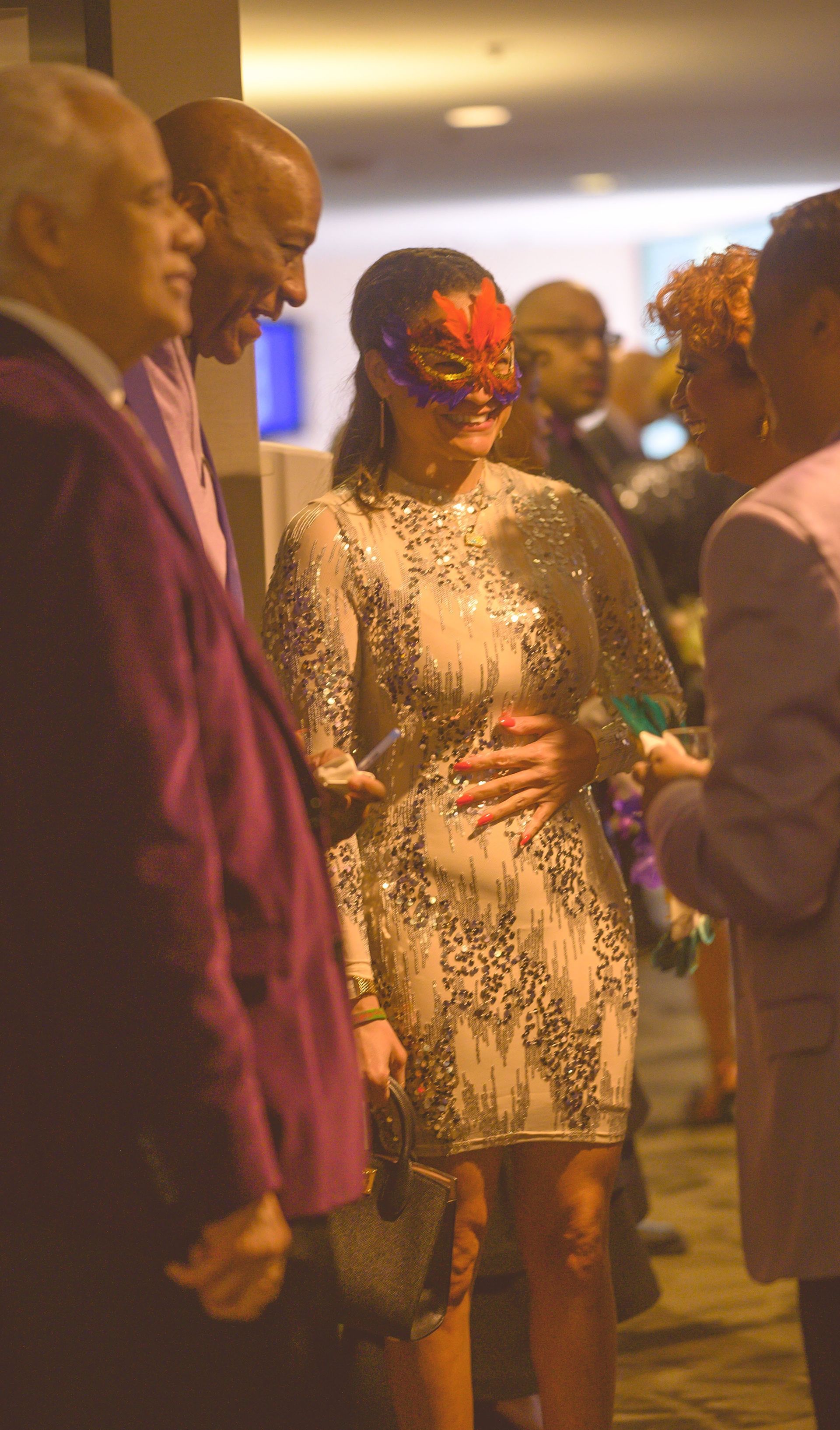 A woman wearing a mask is standing in a crowd of people.