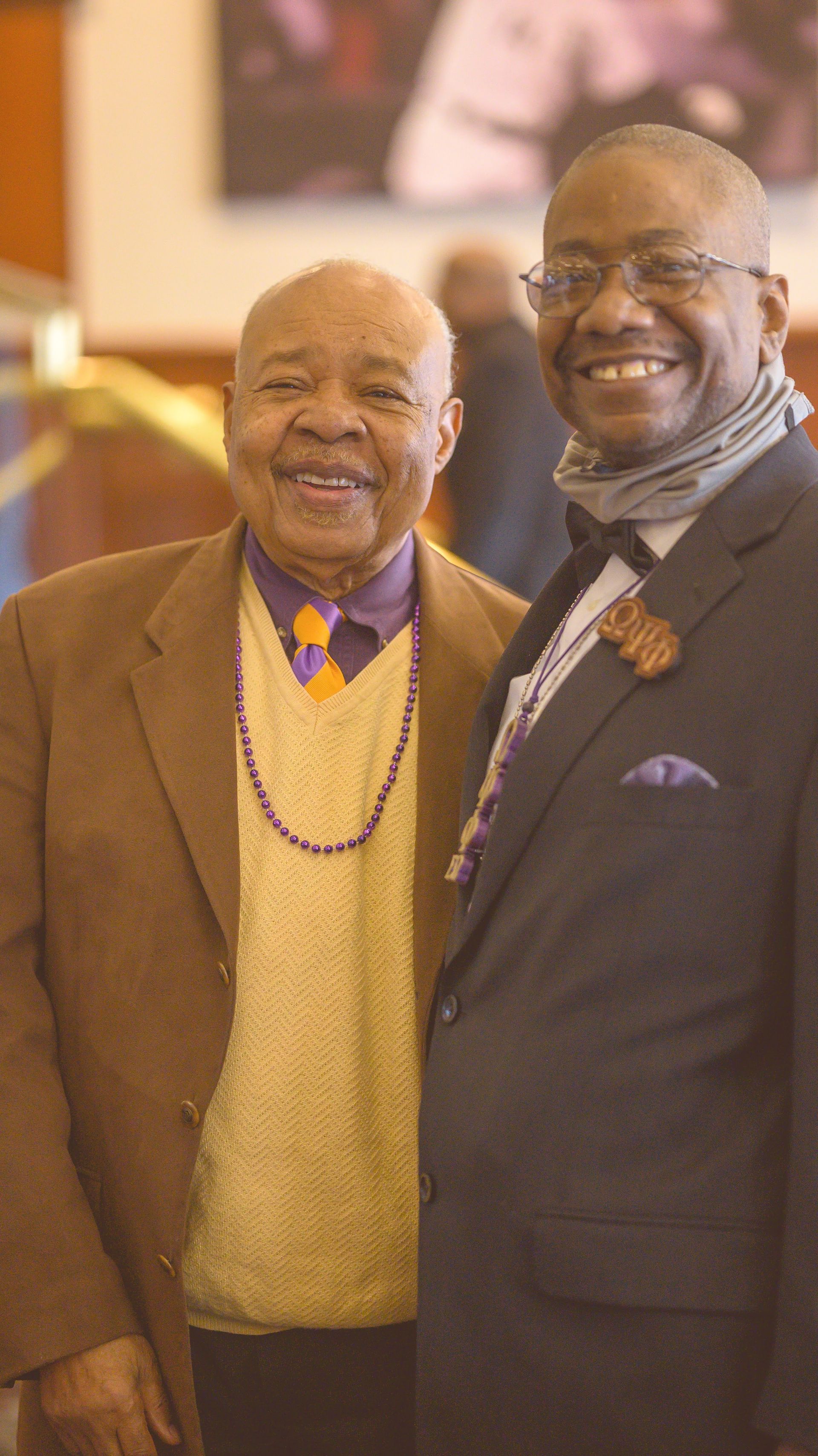 Two men in suits and ties are posing for a picture together.