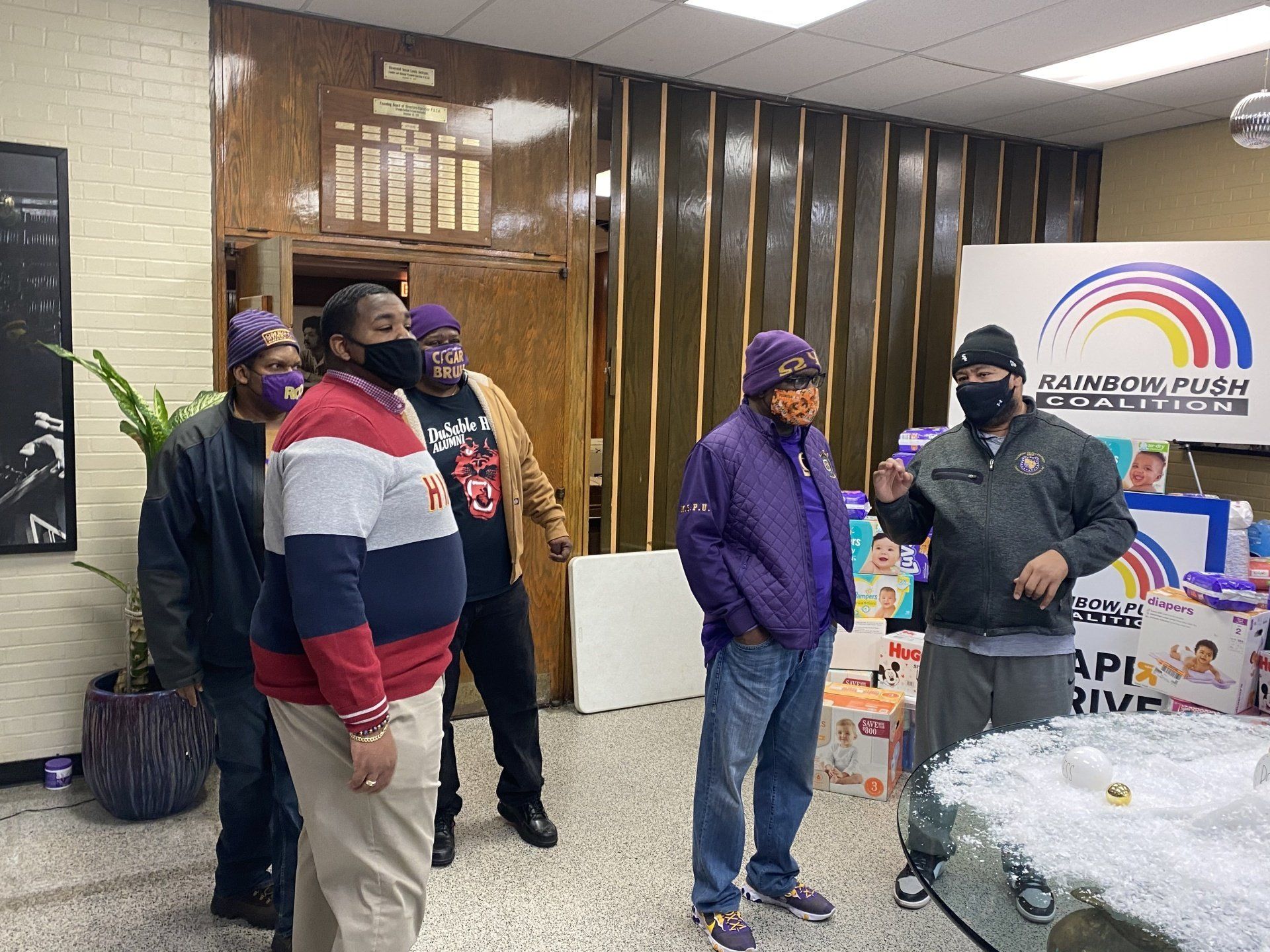 A group of men wearing face masks are standing in a room.