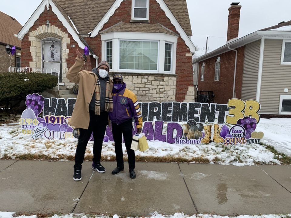A man and a woman are standing in front of a house.