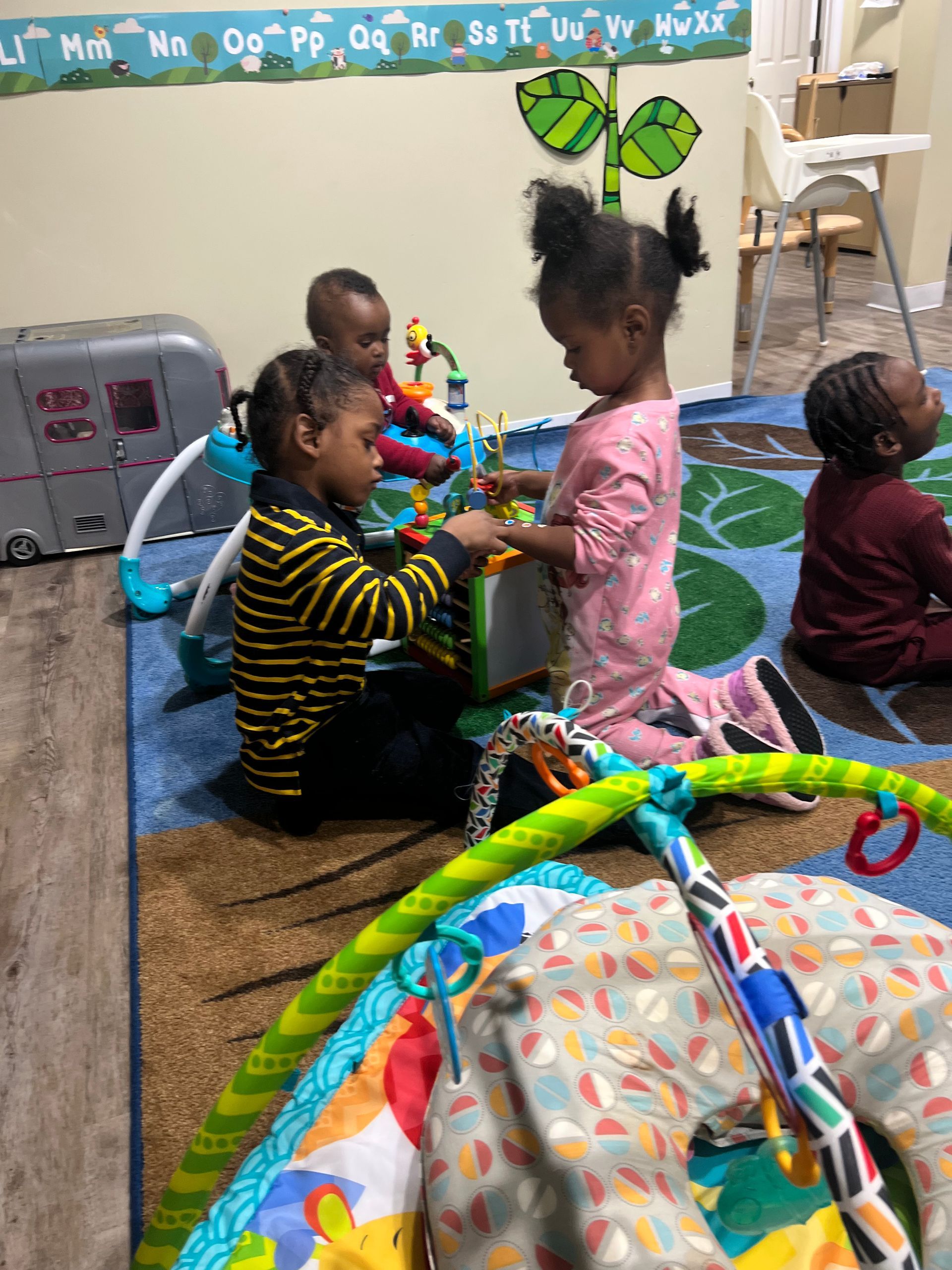 A group of children are sitting on the floor playing with toys.