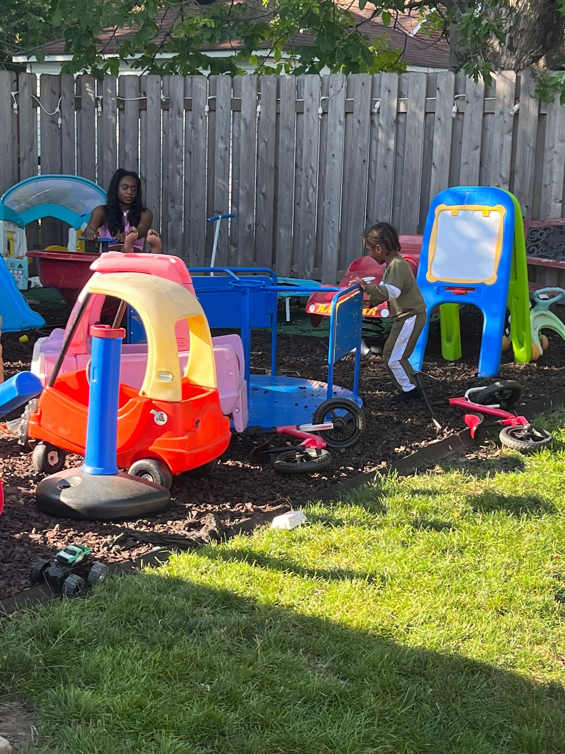 A group of children are playing in a backyard with toys.