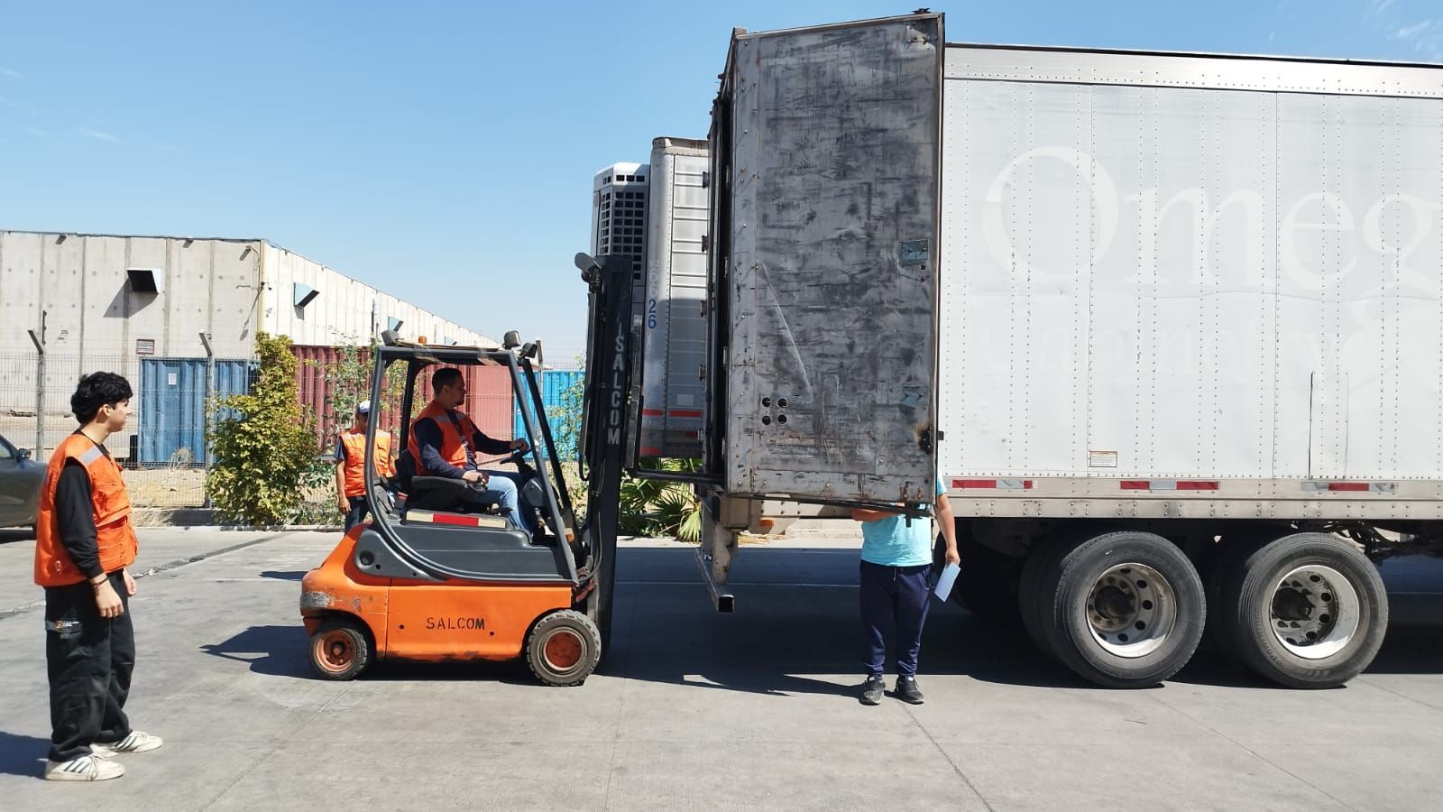 Un hombre está parado en la parte trasera de un camión sosteniendo una caja.
M3GA LOGISTICA