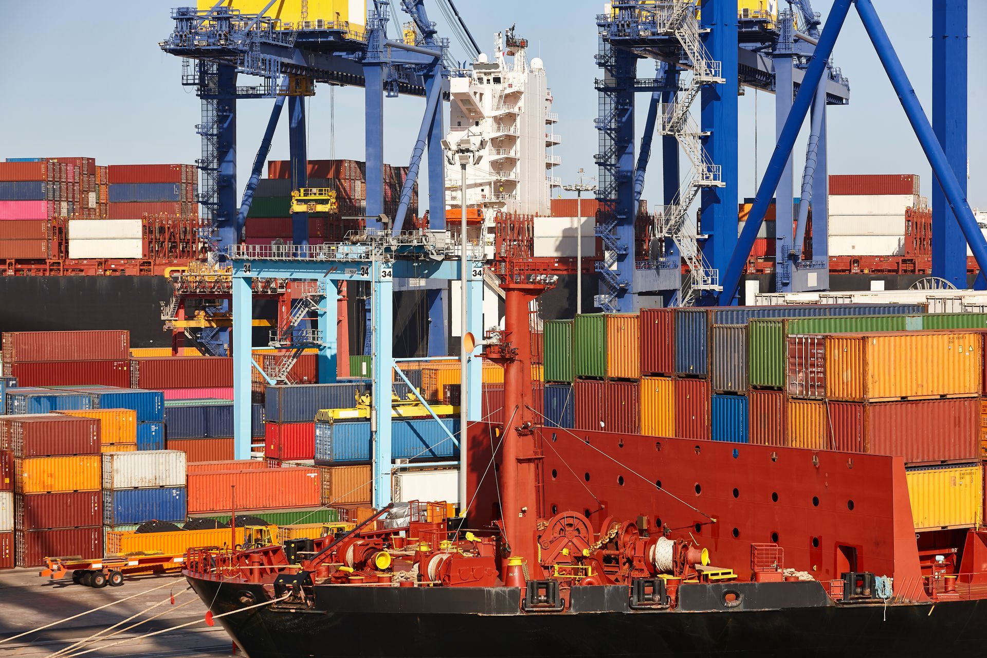 Un gran barco portacontenedores está atracado en un puerto lleno de muchos contenedores.