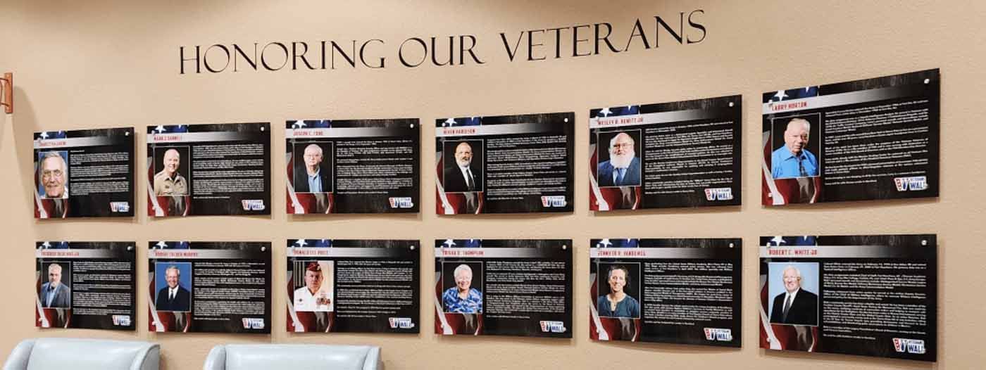 Wall display of veterans with photos, names, and service details; 