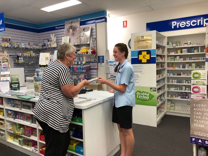 sales lady giving medicine to a senior