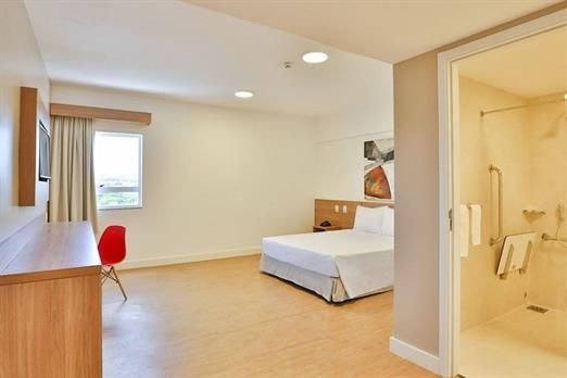 Um quarto de hotel com uma cama king size e um chuveiro