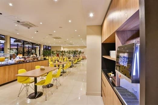 Um restaurante com mesas e cadeiras e um micro-ondas