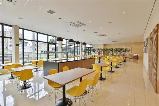 Uma sala grande com mesas e cadeiras.