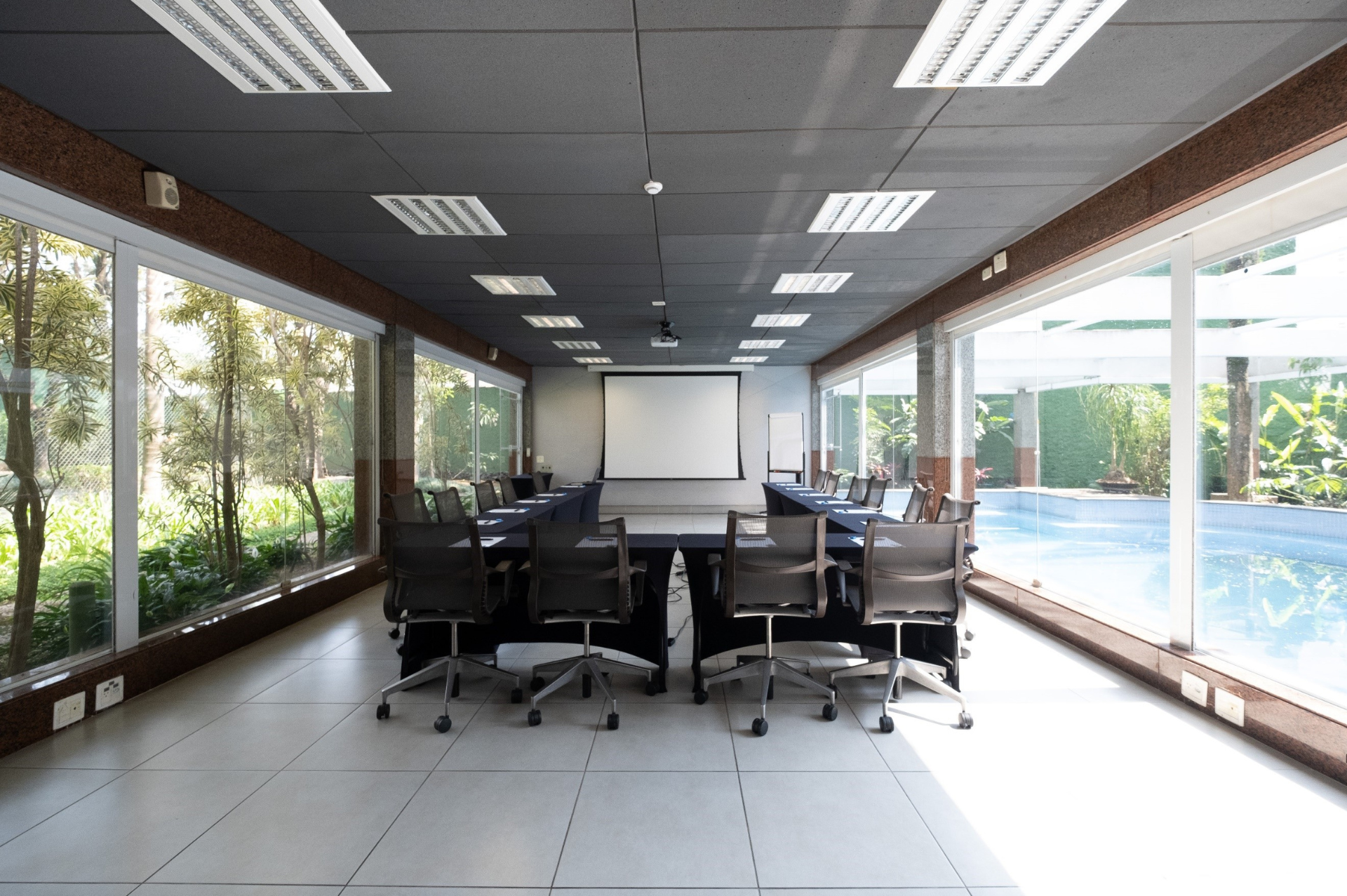 Uma grande sala de conferências com tela de projetor e cadeiras