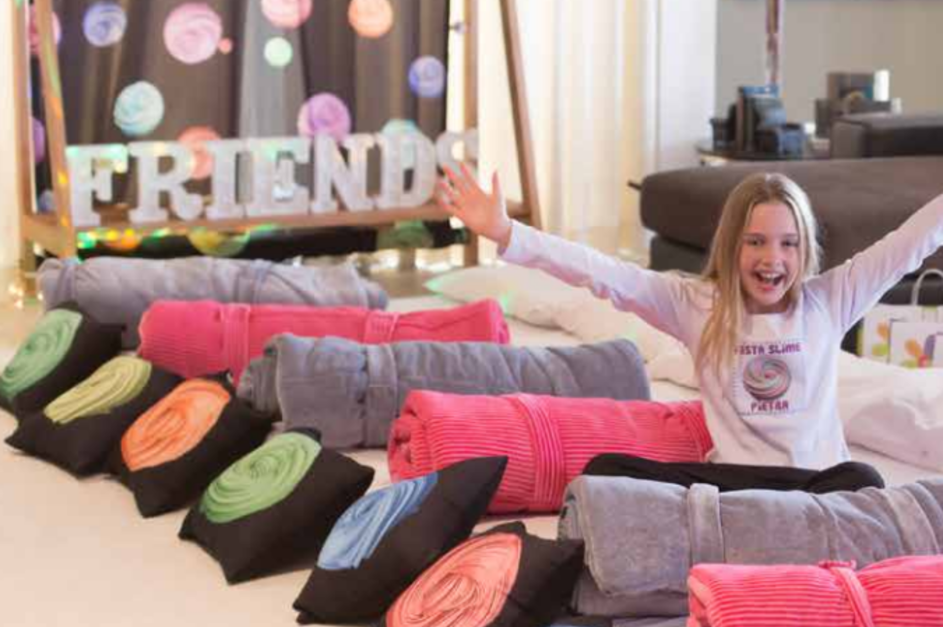 Uma menina está sentada em uma cama com travesseiros e cobertores.