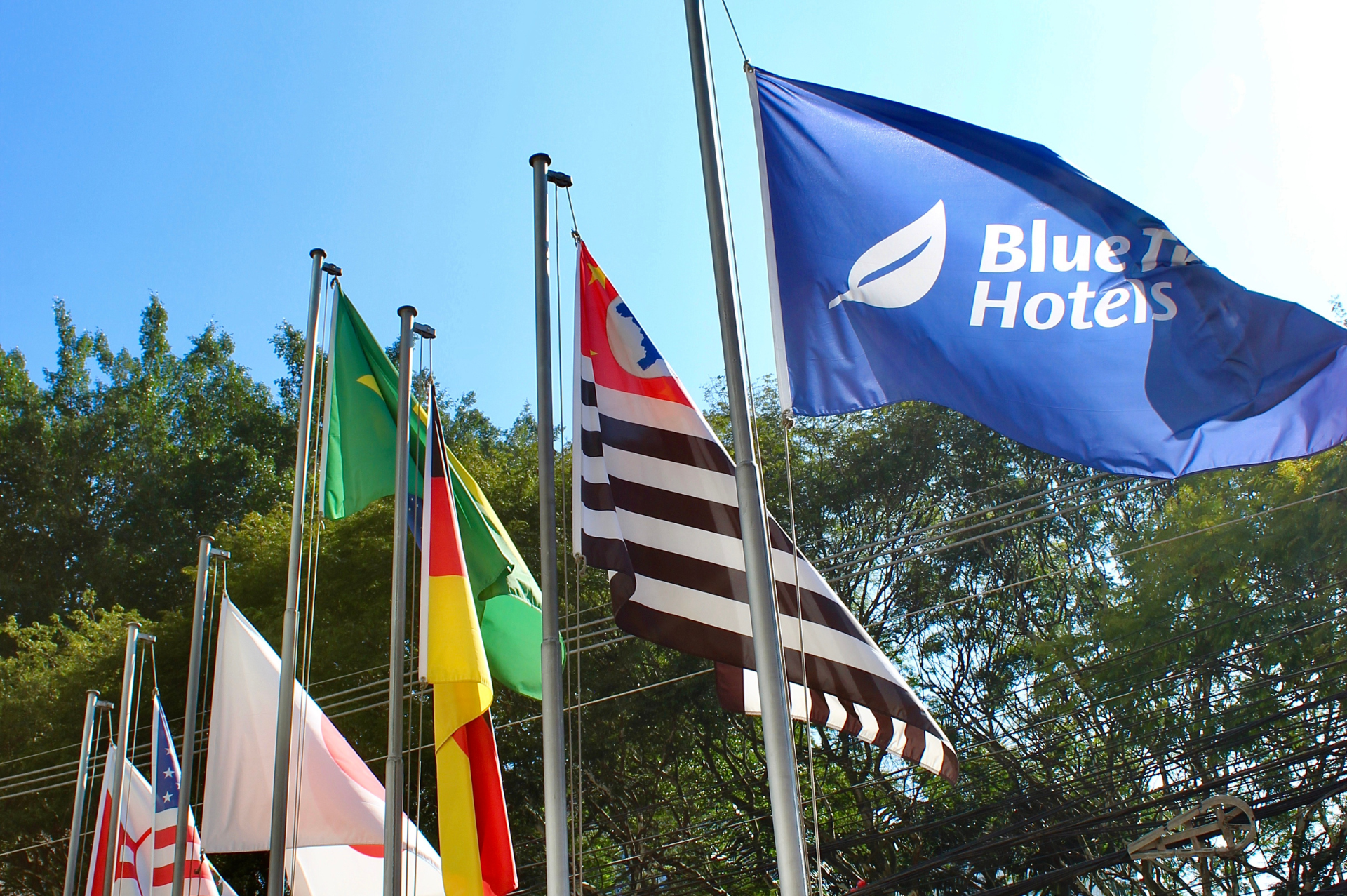 A bandeira de um hotel azul está entre muitas outras bandeiras