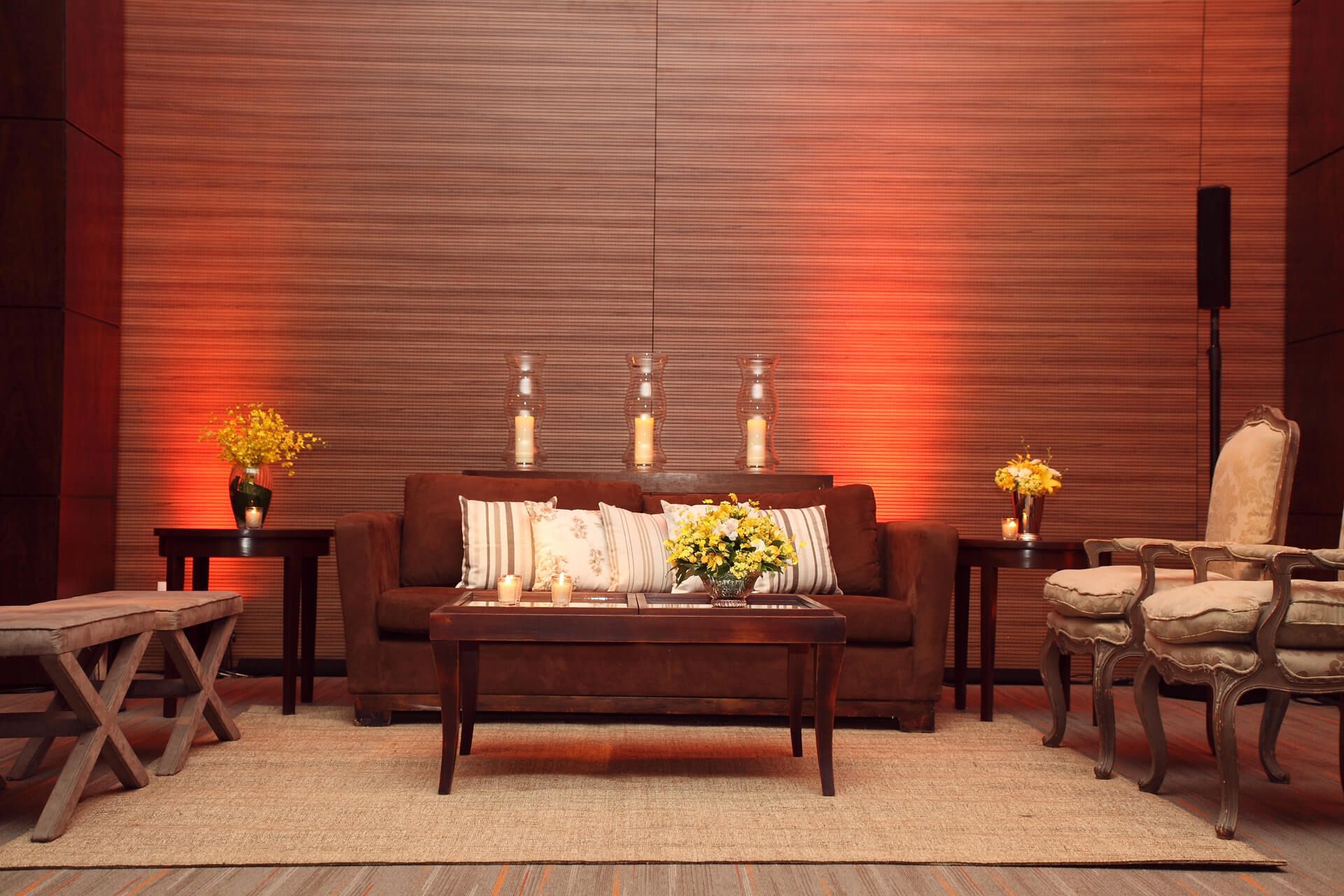 Uma sala de estar com um sofá, mesa, cadeiras e velas.