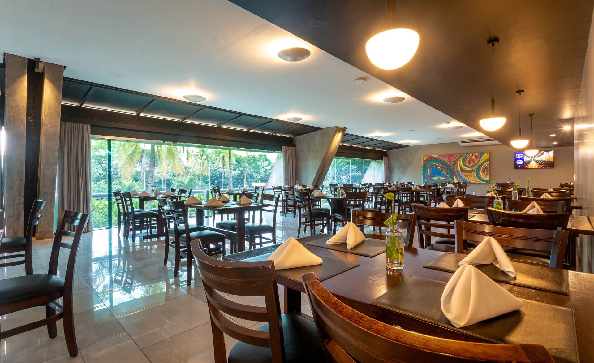 Um grande restaurante com mesas, cadeiras e guardanapos sobre elas
