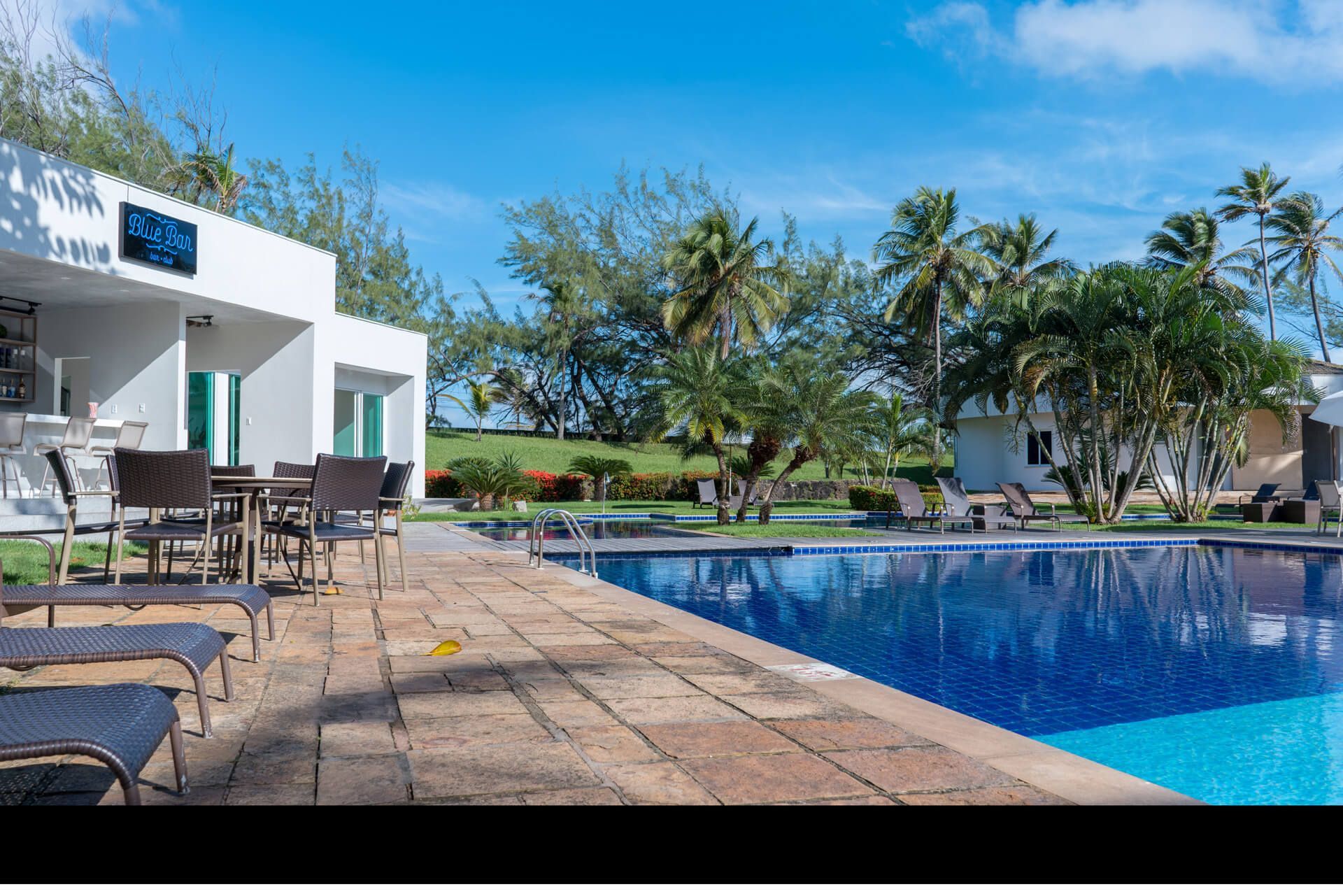 Uma grande piscina com mesas e cadeiras ao redor