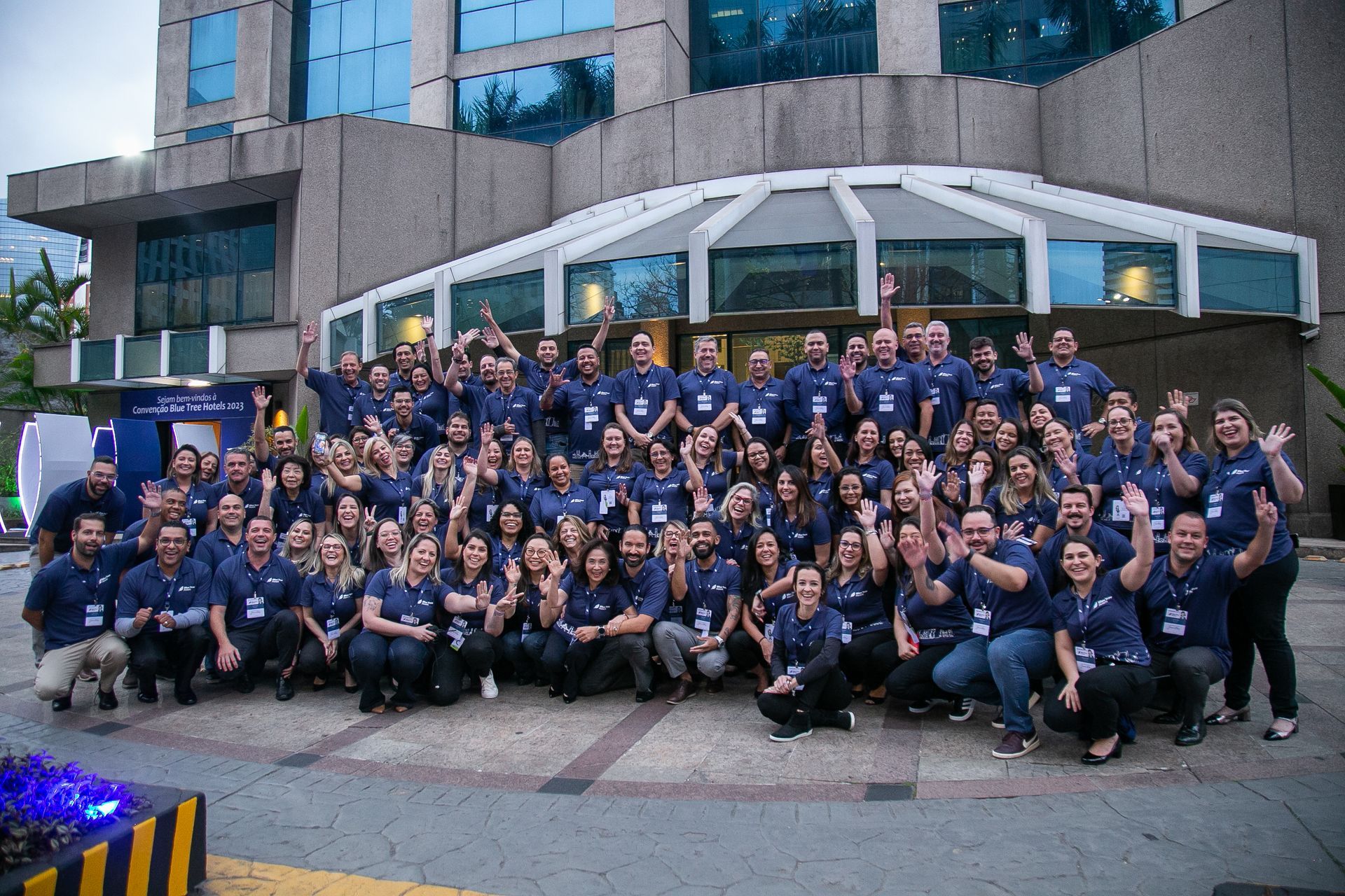 Um grande grupo de pessoas está posando para uma foto em frente a um prédio.