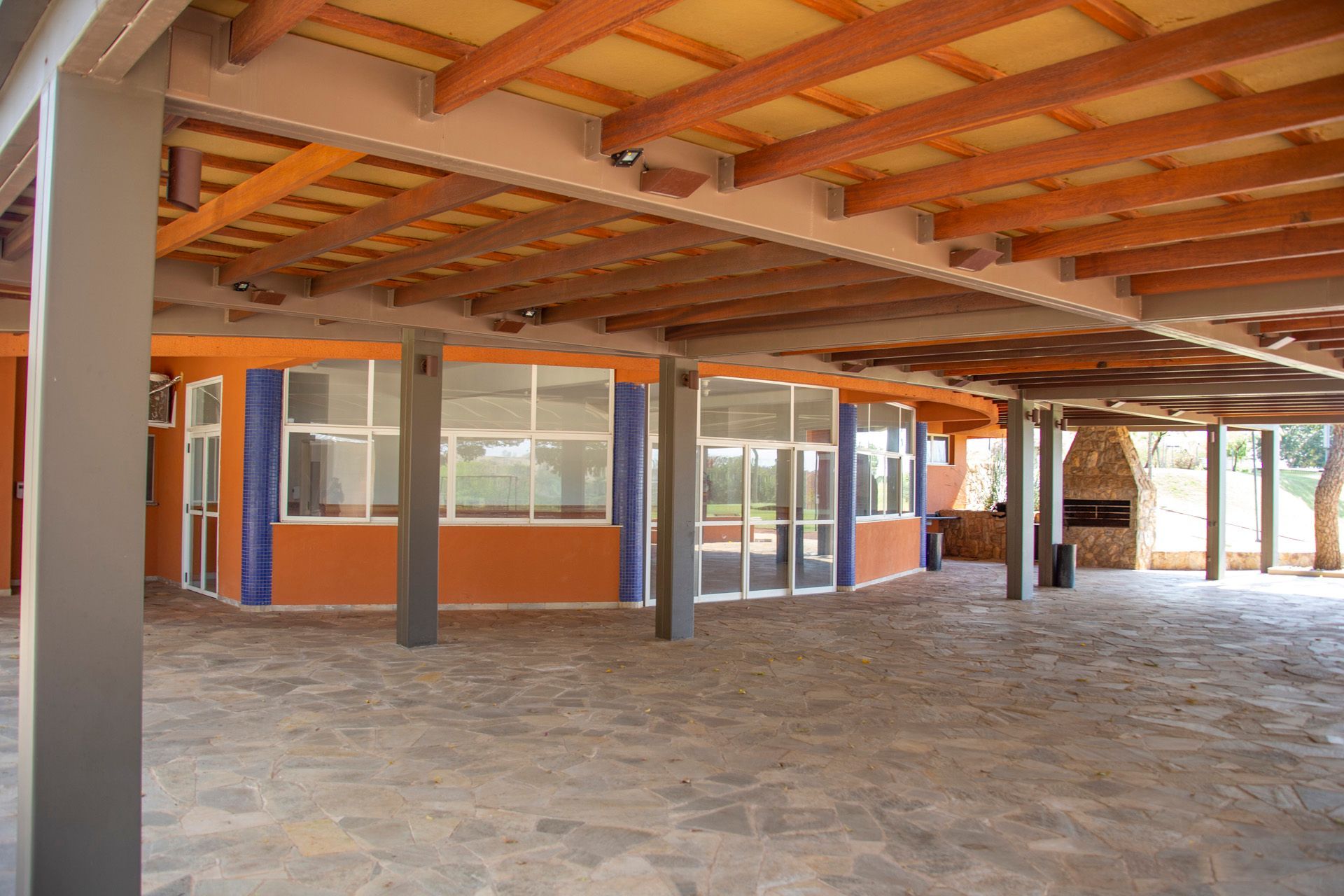 Uma grande sala vazia com teto de madeira e pilares