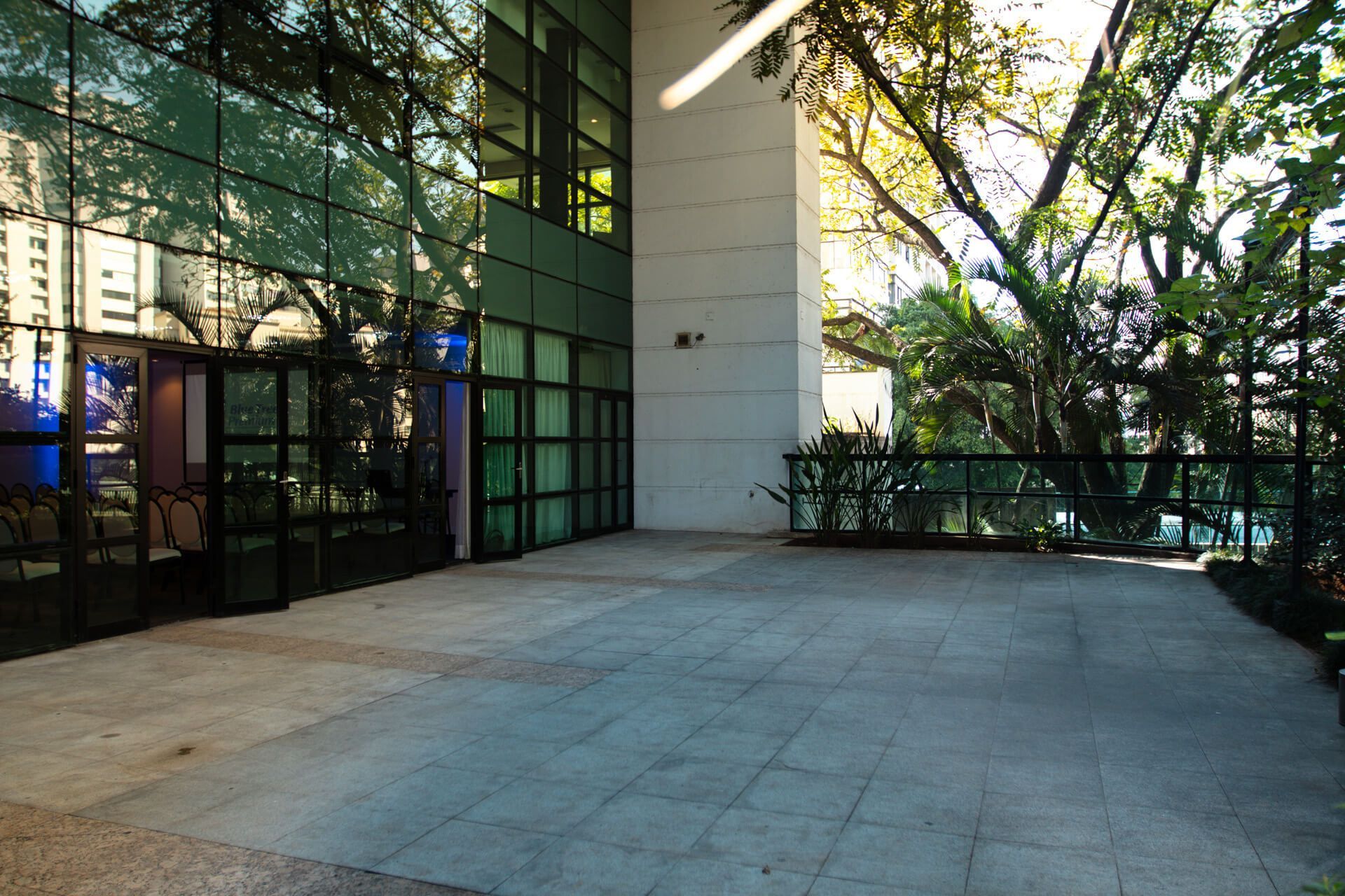 Um grande edifício com muitas janelas e árvores ao fundo