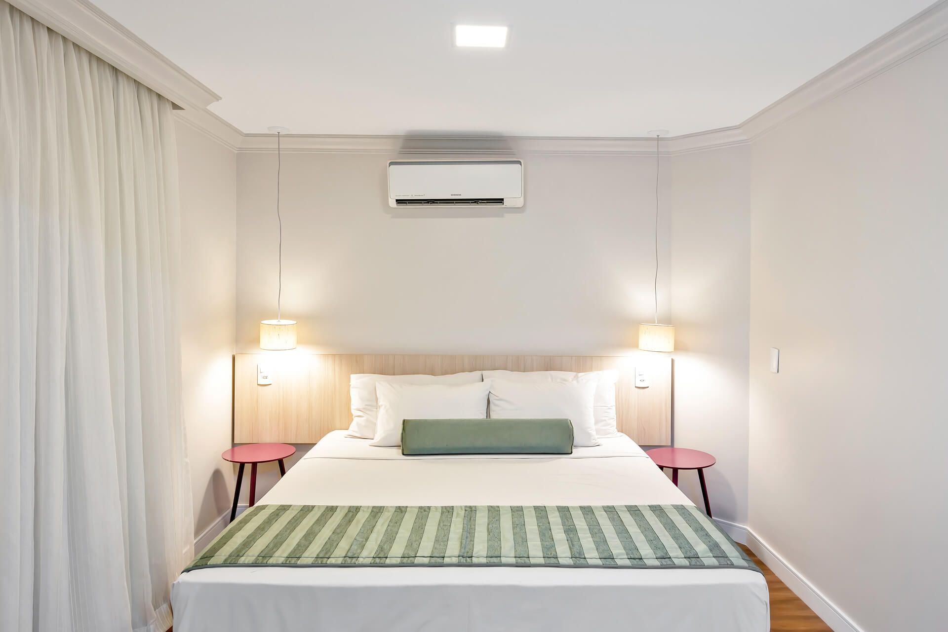 Um quarto com uma cama e um ar condicionado no teto