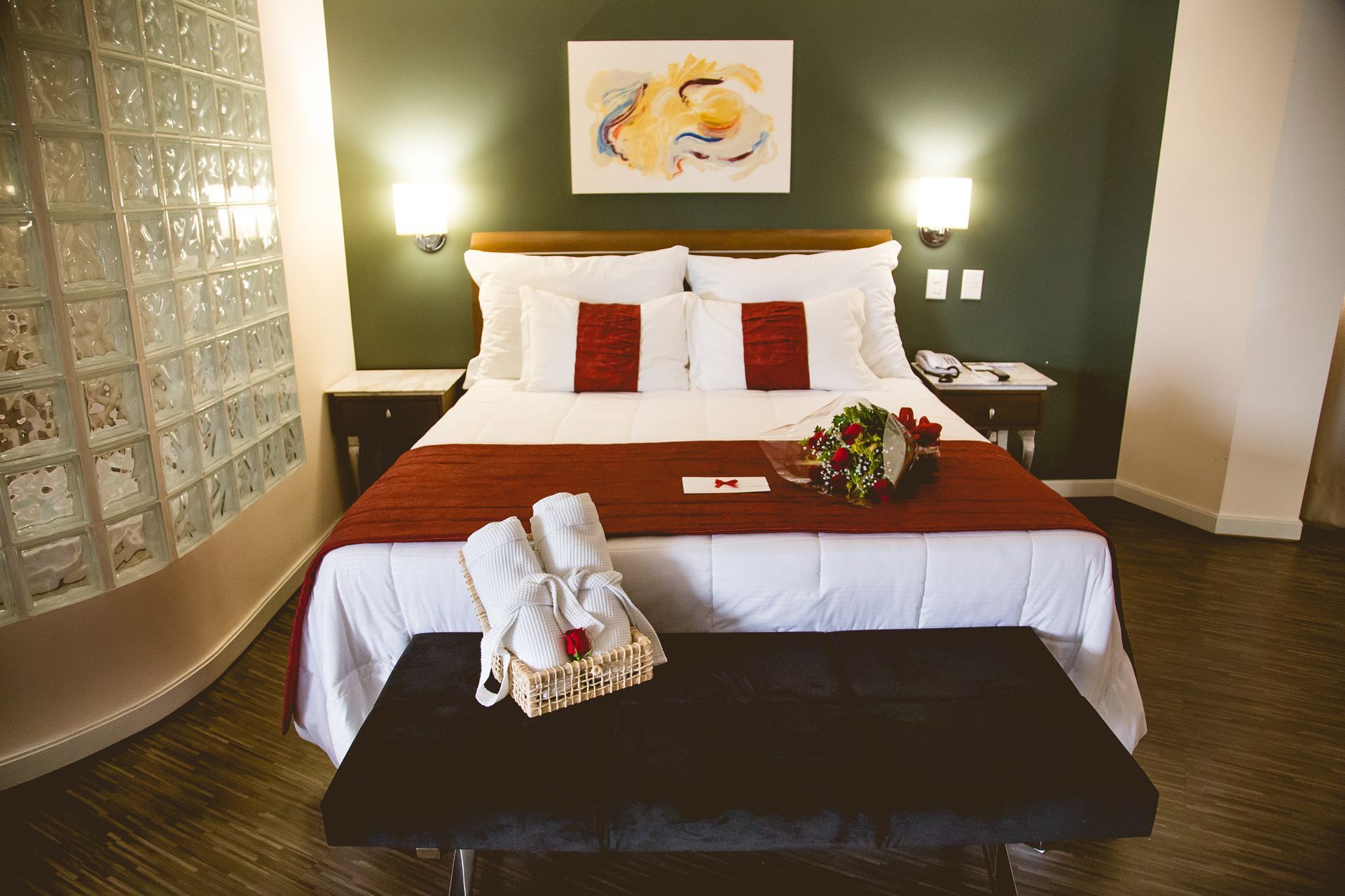 Um quarto de hotel com uma cama king size e um banco.