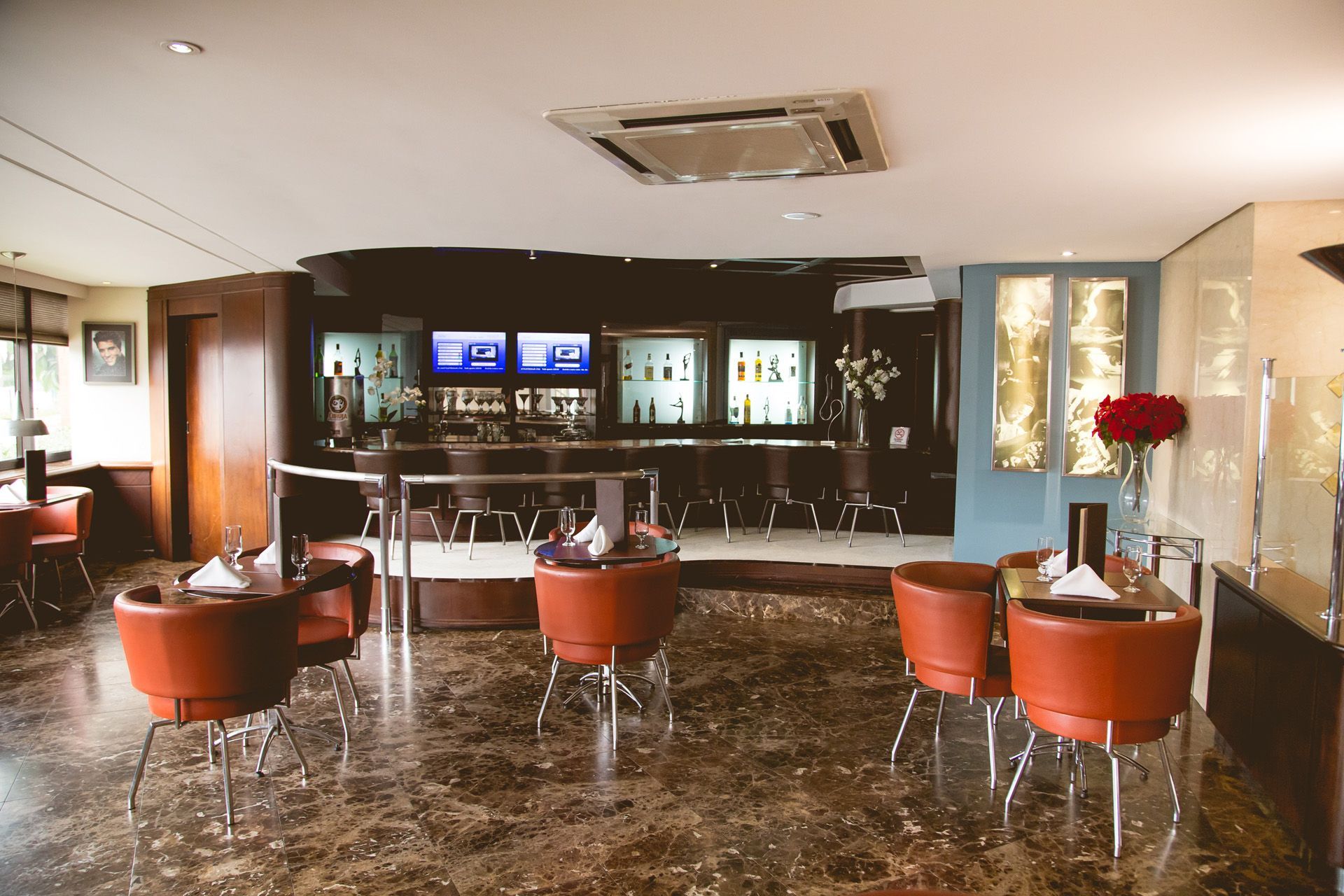 Um restaurante com mesas e cadeiras e um bar