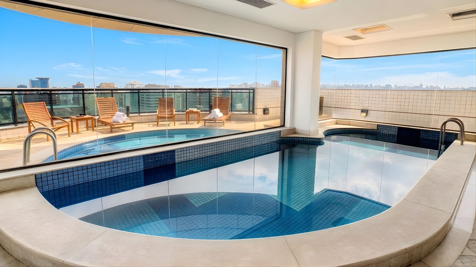 almofadas com piscina e palmeiras ao fundo
