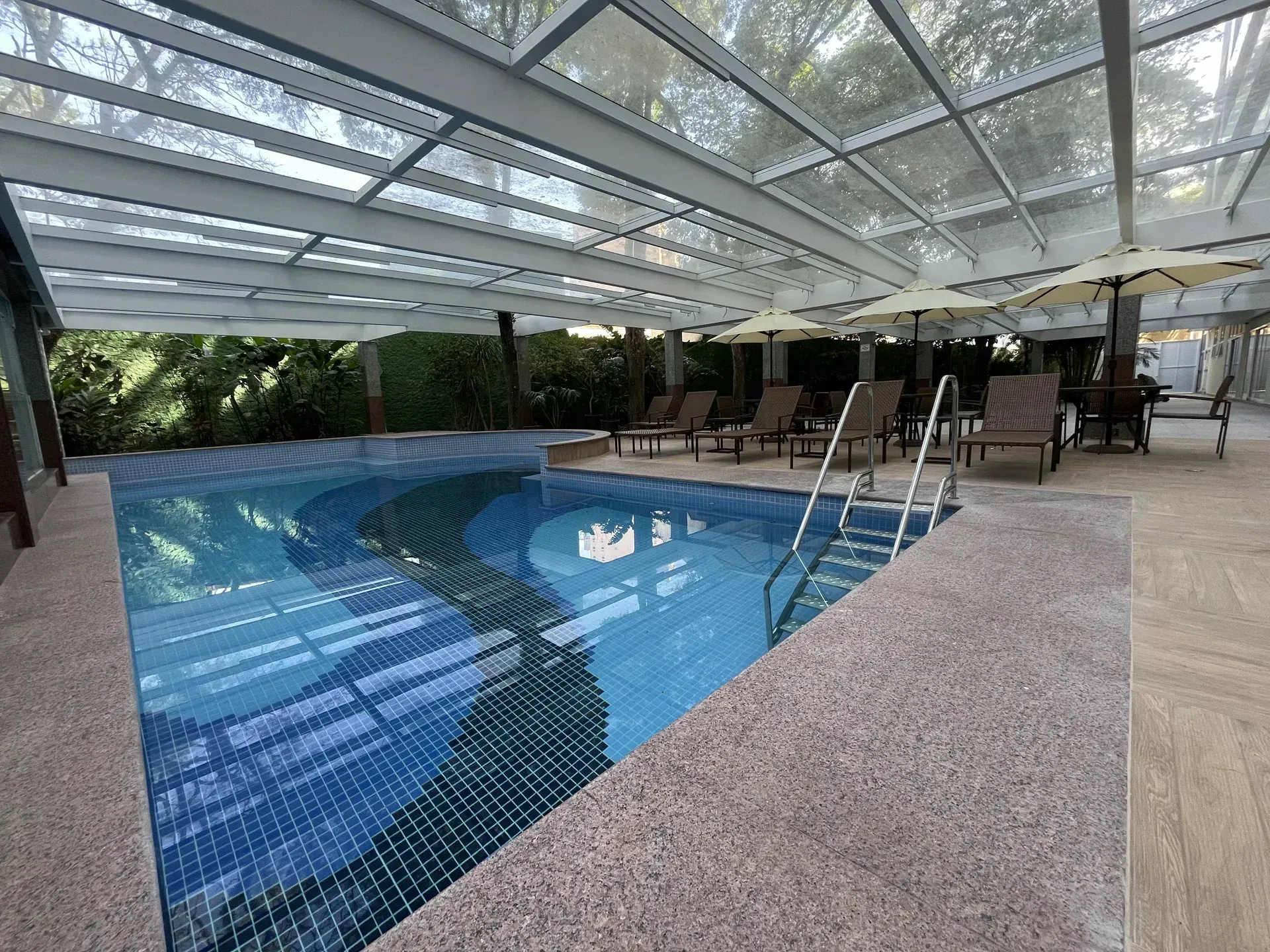 Uma piscina com uma árvore em primeiro plano