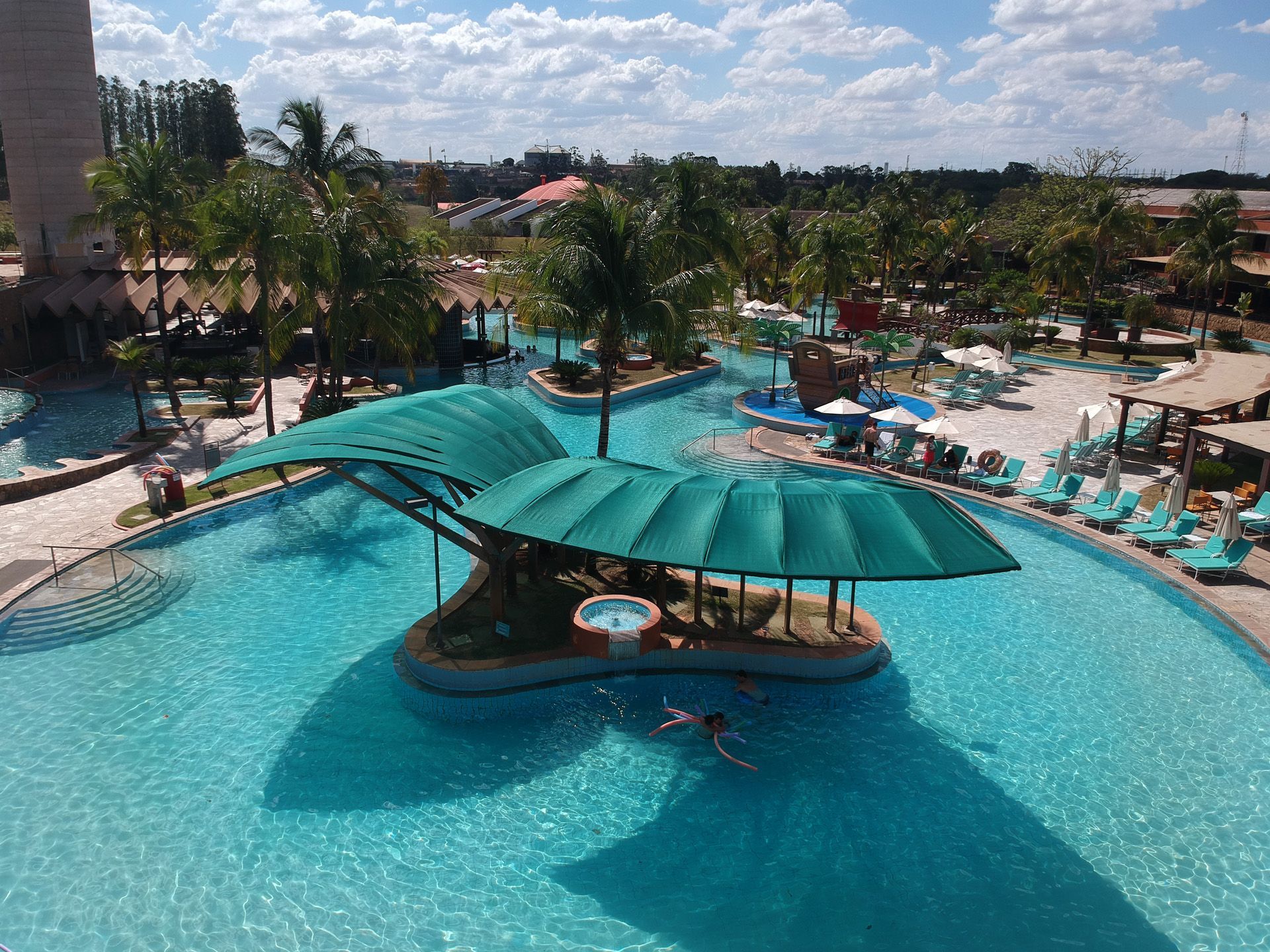 Uma vista aérea de uma grande piscina com um bar no meio.