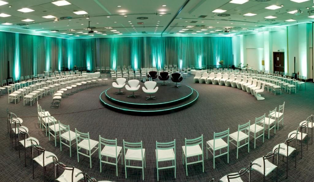 Uma grande sala de conferências com fileiras de mesas e cadeiras