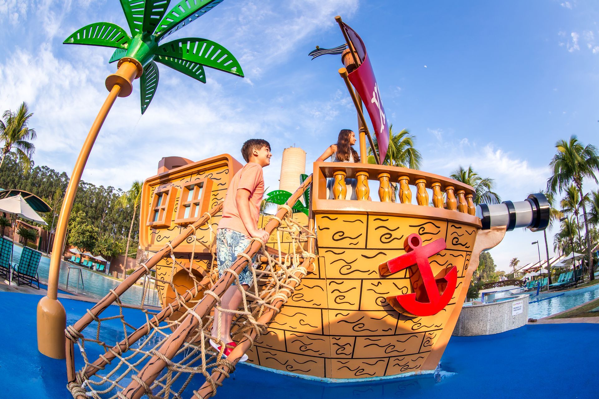 Duas crianças estão brincando em um navio pirata em um parque aquático.
