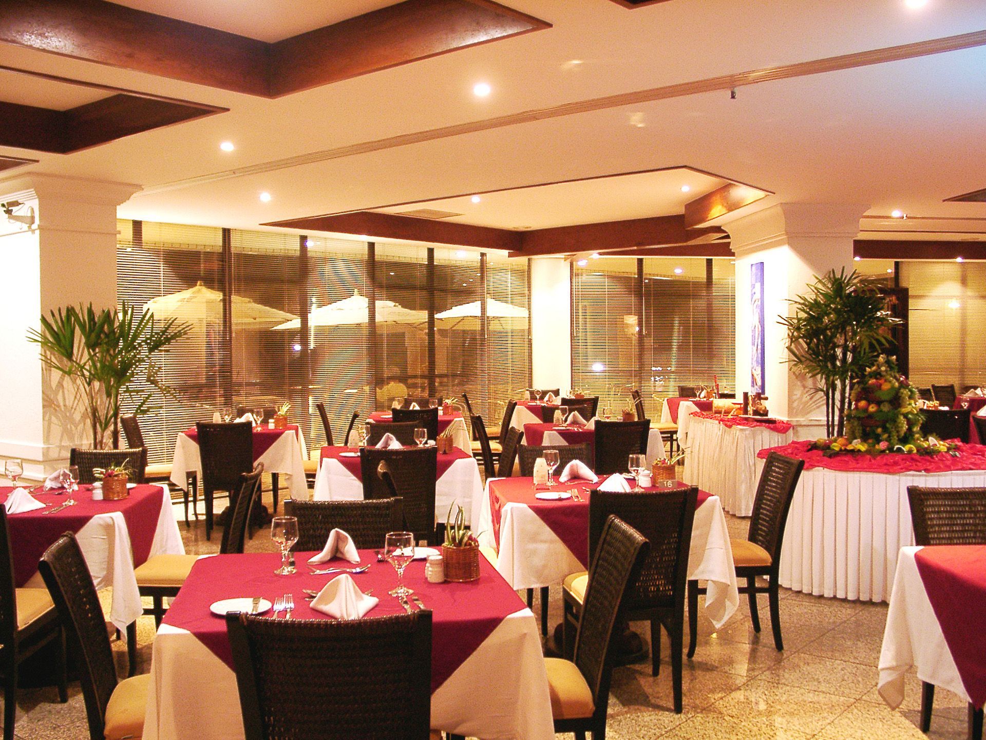 Um restaurante com mesas e cadeiras preparadas para o jantar