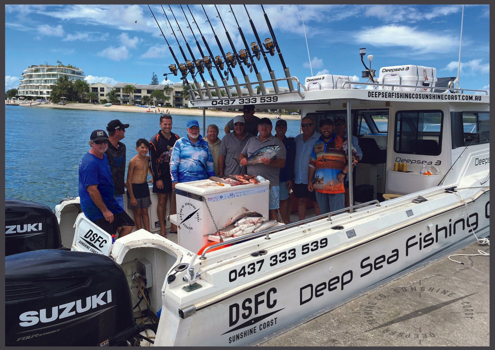 A group of people standing on a boat that says deep sea fishing